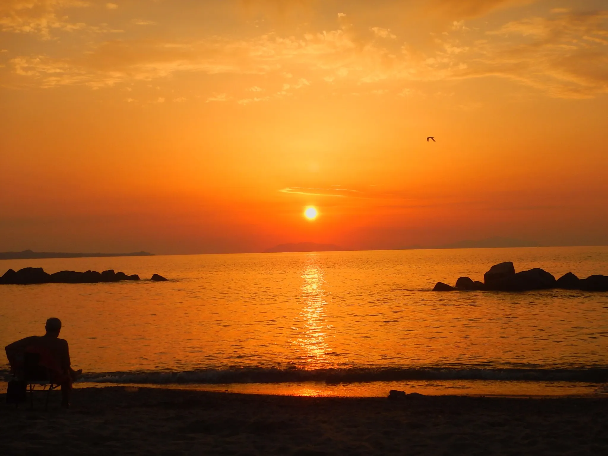 Photo showing: the beach of Rometta facing cape Milazzo and Aeolian islands at the sunset, Sicily