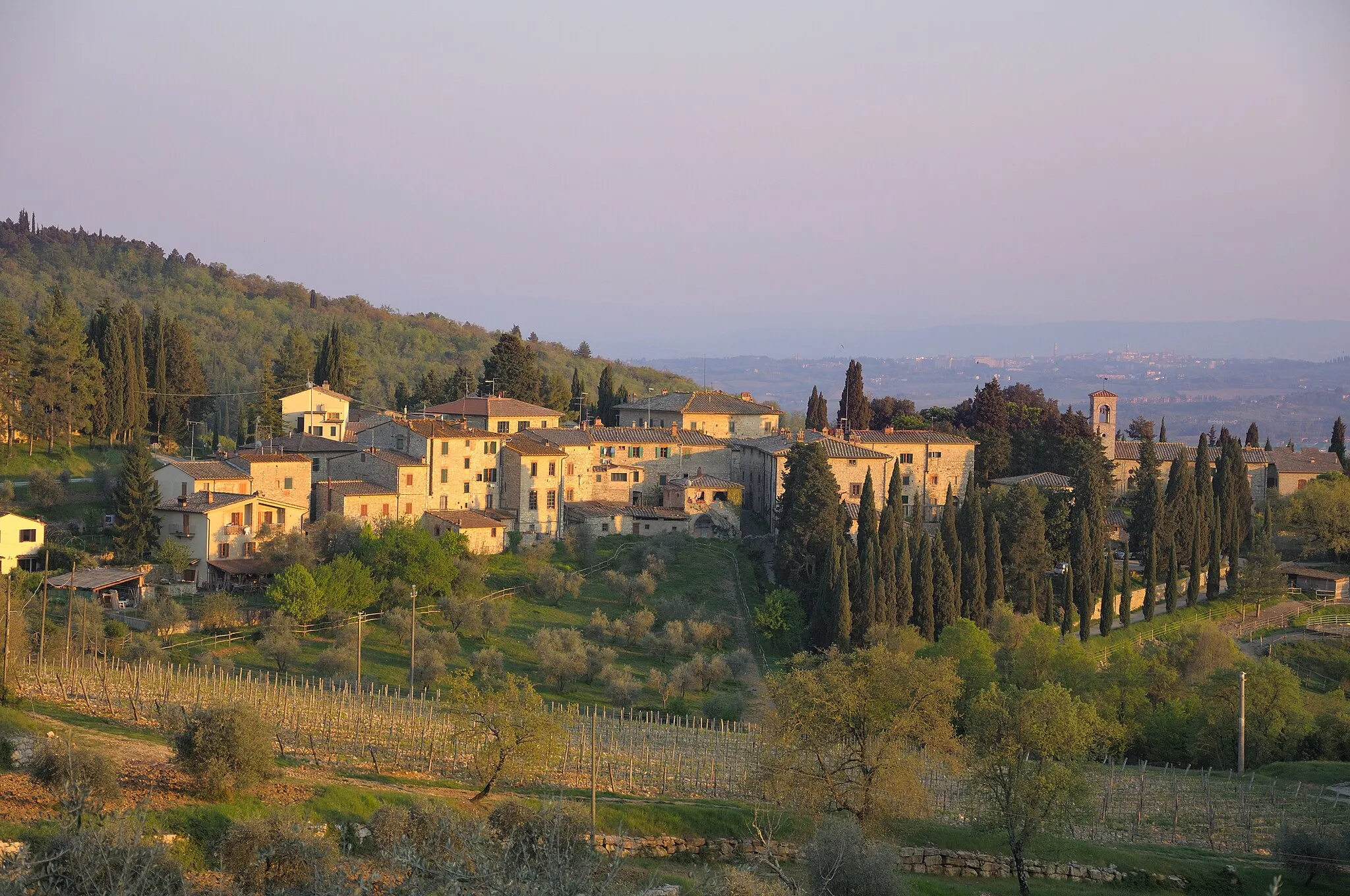 Photo showing: View of the hamlet Fonterutoli, a frazione of Castellina in Chianti, Tuscany, Italy.  View from north-north-west shortly before sunset.  In the background you can see Siena. Hint: The original Flickr file name and description identify the hamlet as Panzano, but the photo shows Fonterutoli.