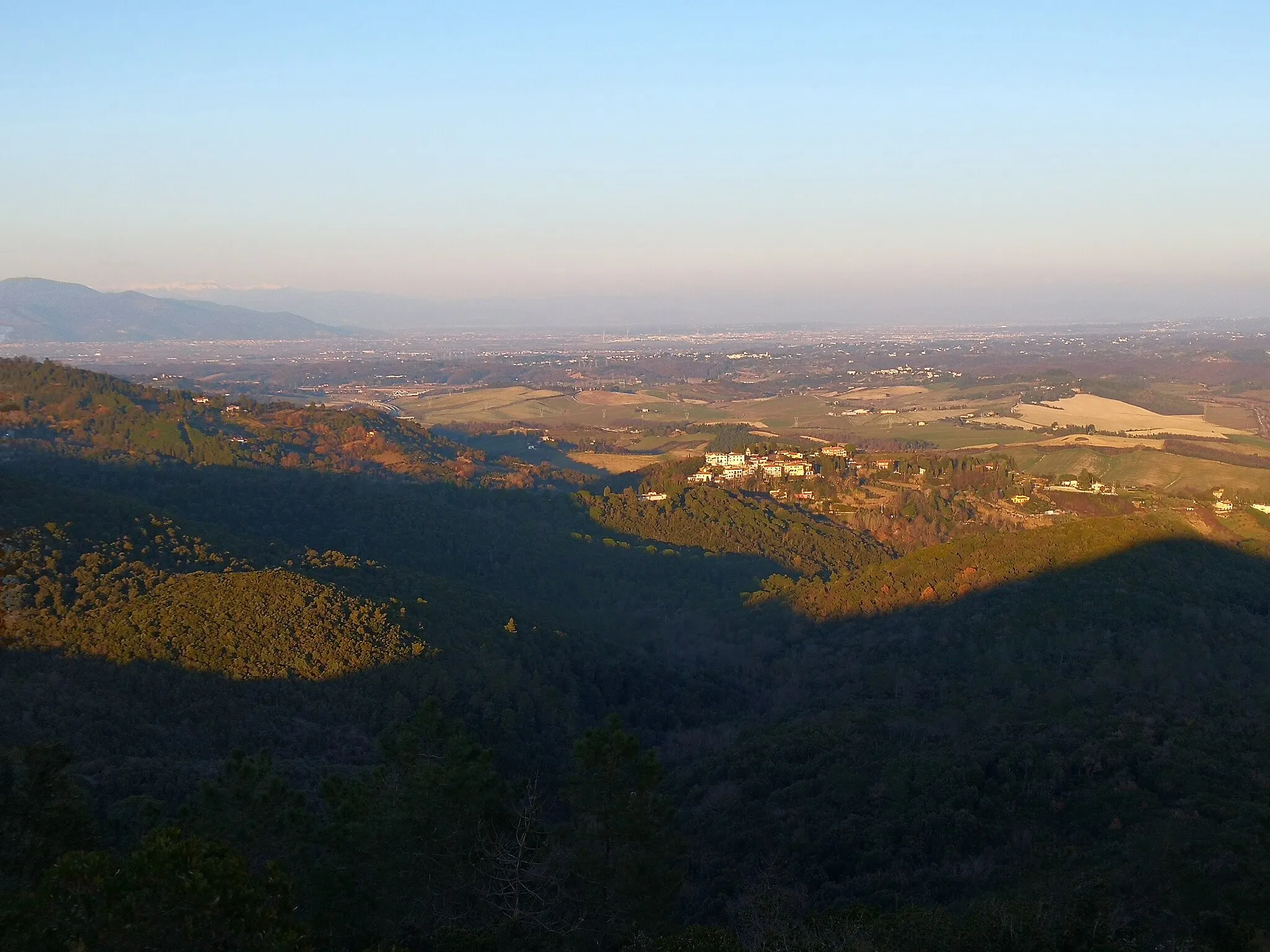 Photo showing: Panorama verso nord-est dall'apertura orientale del Monte Auto.
Fra i vari elementi geografici, sono visibili, da sinistra a destra:

-) la parte orientale dei Monti Pisani e, sullo sfondo, l'Appennino Tosco-Emiliano innevato; -) l'impianto eolico di Pontedera e la piana Pontederese; -) più in vicinanza, i borghi di Fauglia e di Luciana; -) in primo piano, la frazione di Colognole.