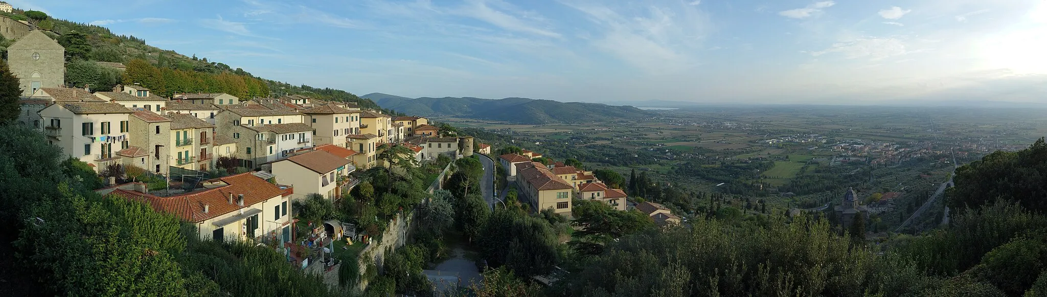 Photo showing: A panorama photographed from the Piazza Garibaldi in Cortona, Tuscany, Italy. It shows Cortona, on the hill to the left, its village, Camucia, in the plain on the center right, and, in the center background, Lake Trasimeno.