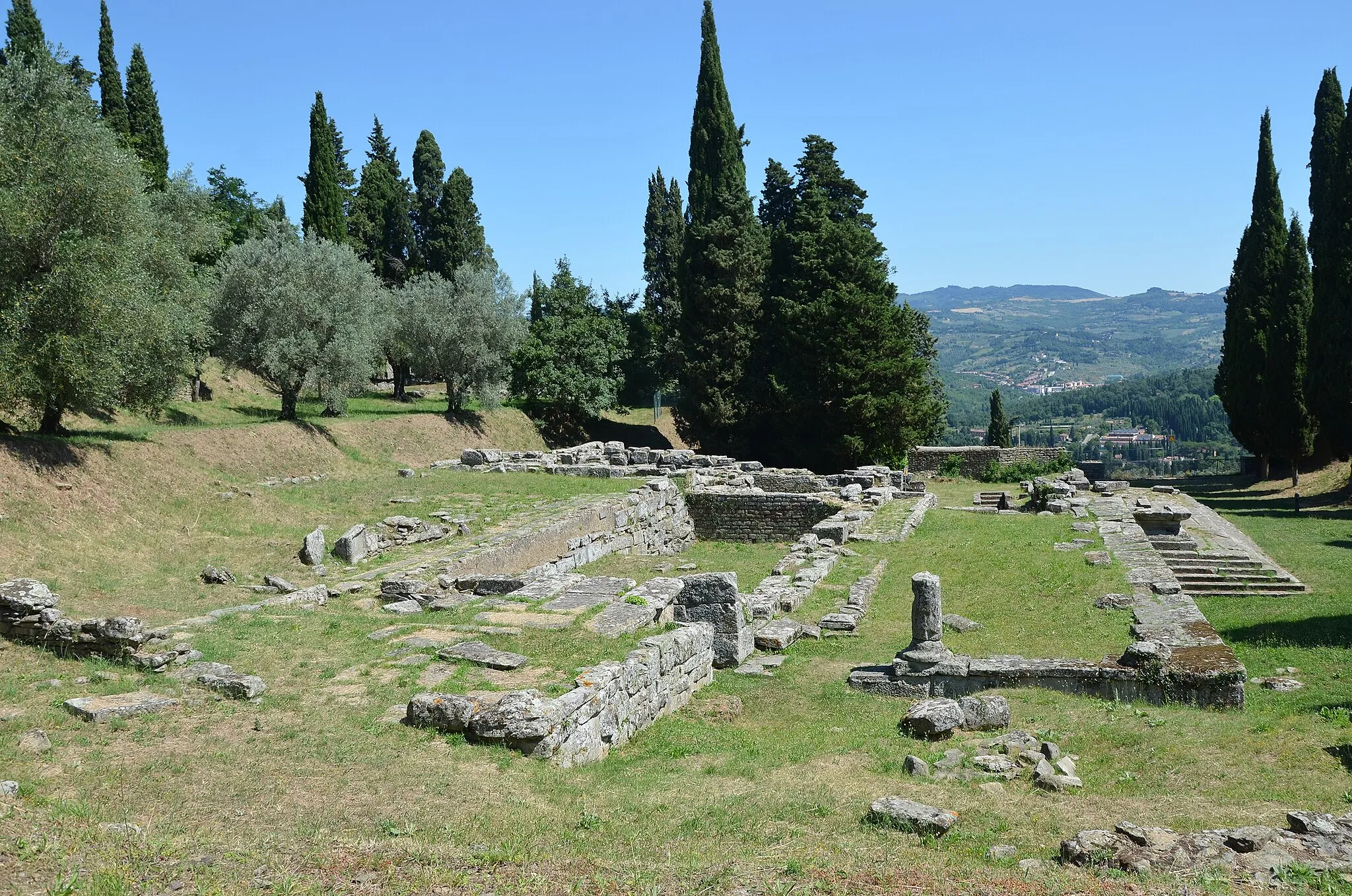 Photo showing: The Temple stands opposite the spa. In Roman times, the two were linked by a road. There was a pre-Roman temple, a building from the Etruscan era built around the late 4th Century B.C. which was much smaller and simpler in layout with a single cell – the holy chamber – which housed the image of the divinity. This cell had two adjacent rooms. Outside there was a colonnade accessed by climbing up steps that still exist today. The floor was in beaten earth and the walls were coated with red plaster. The votive offerings came from the cell and comprised small bronzes and coins now exhibited in the museum.

There was an altar in front of the temple. The Etruscan building was roofed in flat and rounded tiles and its gable had a relief decoration very little of which still remains. It is thought that the temple was dedicated to a beneficial divinity, perhaps Minerva. This building was destroyed by fire in the first Century B.C. when the Romans conquered Fiesole and a new, bigger temple was built in its place. On the southern side there was a rectangular area, the stoà, for pilgrims to rest. Indeed in ancient times only the priest was allowed inside the temple.