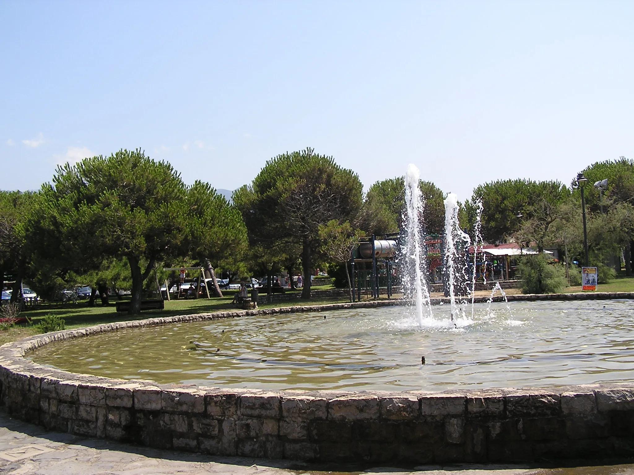 Photo showing: The square of Ronchi di Massa, with a fountain, gardens and games for children.