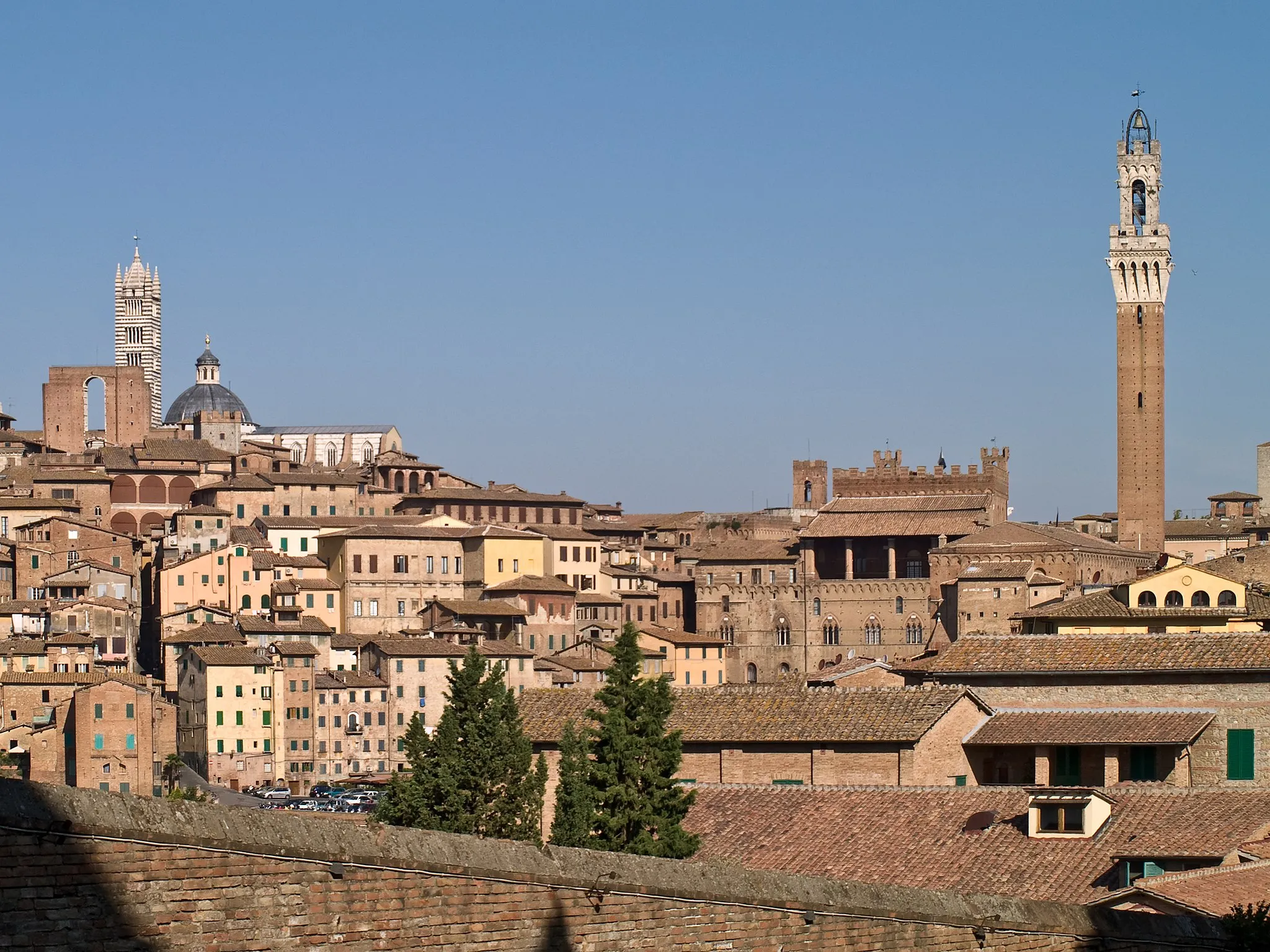 Photo showing: Siena, seen from Santa Maria dei Servi. On the left, top of the hill, the cathedral of Siena (Santa Maria Assunta or Duomo di Siena) and the Facciatone. On the right, the back of the Palazzo Pubblico and the Torre del Mangia.