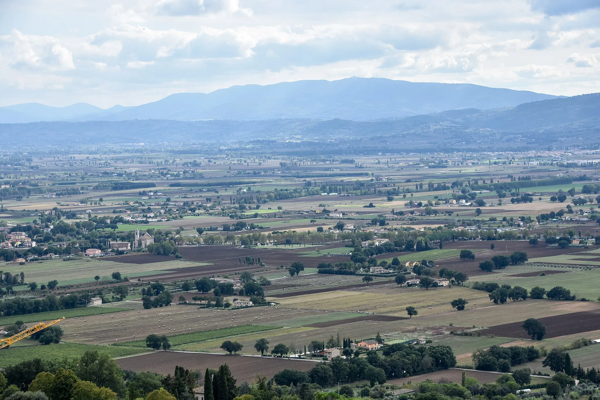 Photo showing: Plains with fields and villages, south-west of Assisi.  Santuaro de Rivotorto (left of centre), Bastia (right). Province of Perugia, Italy