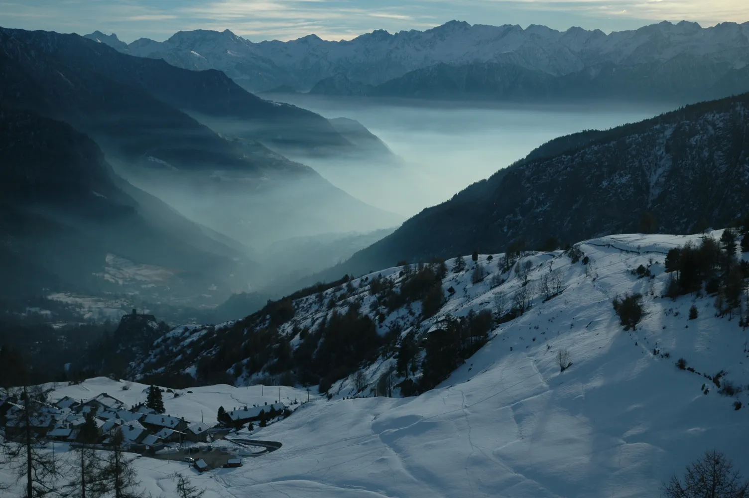 Photo showing: La vallée de Challant de la route pour Estoul : en bas les villages de Fénille et le Château de Graines, au fond à gauche le Col Courtil qui sépare la Vallée de Champorcher de la vallée centrale de la Doire Baltée.