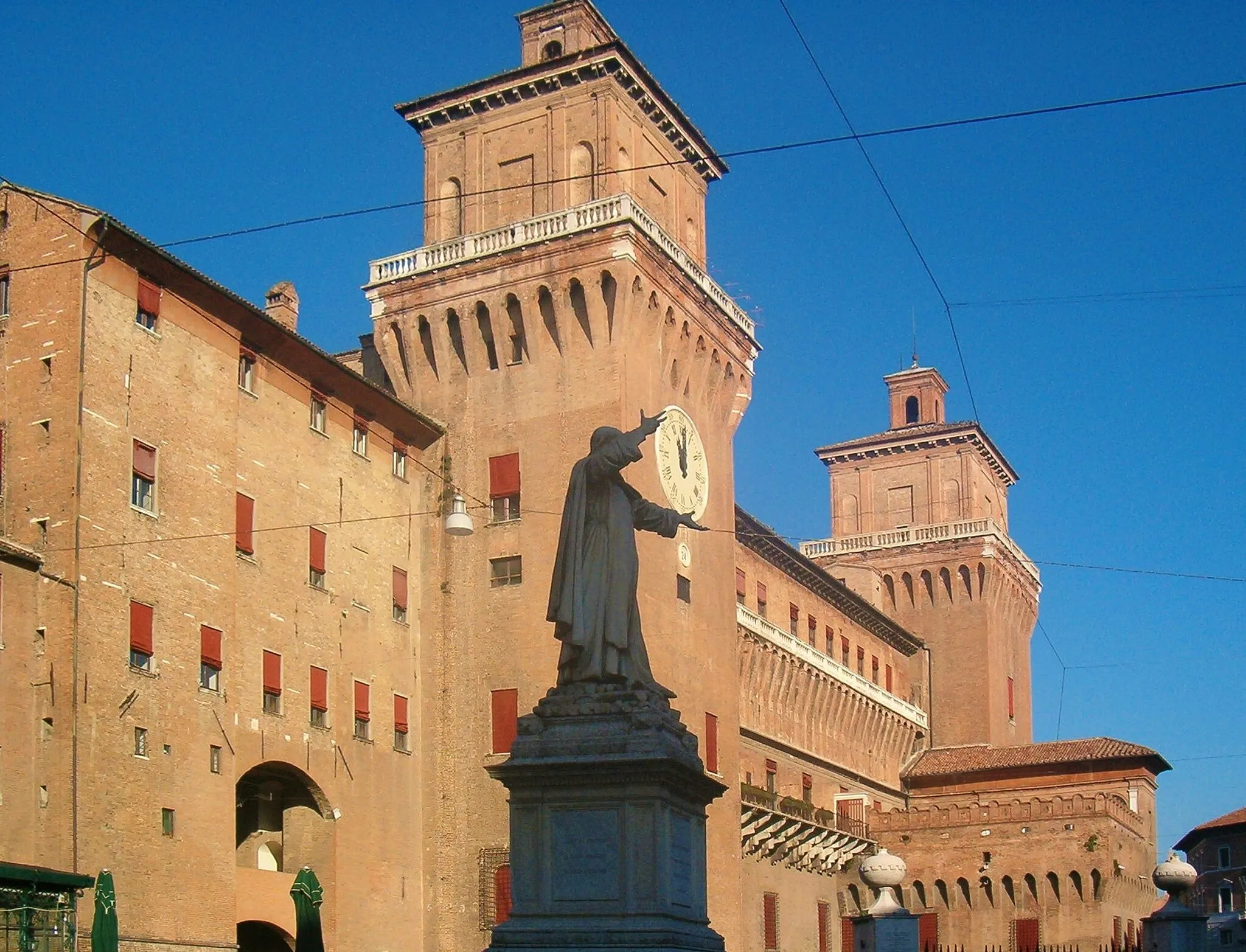 Photo showing: Statua di Girolamo Savonarola in Piazza Savonarola, a Ferrara, in una tipica inquadratura. Il frate sembra tenere tra le mani l'orologio posto sulla torre Marchesana del Castello Estense.