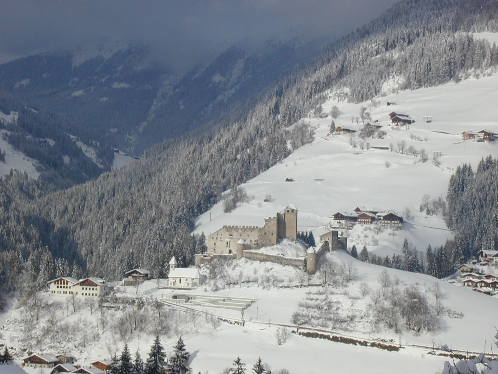 Photo showing: Das Bild zeigt die Burg Heinfels. Im Vordergrund die Kirche St. Peter und unterhalb die Volksschule. Im Hintergrund eröffnet sich dem Betrachter der Blick in das Villgratental.