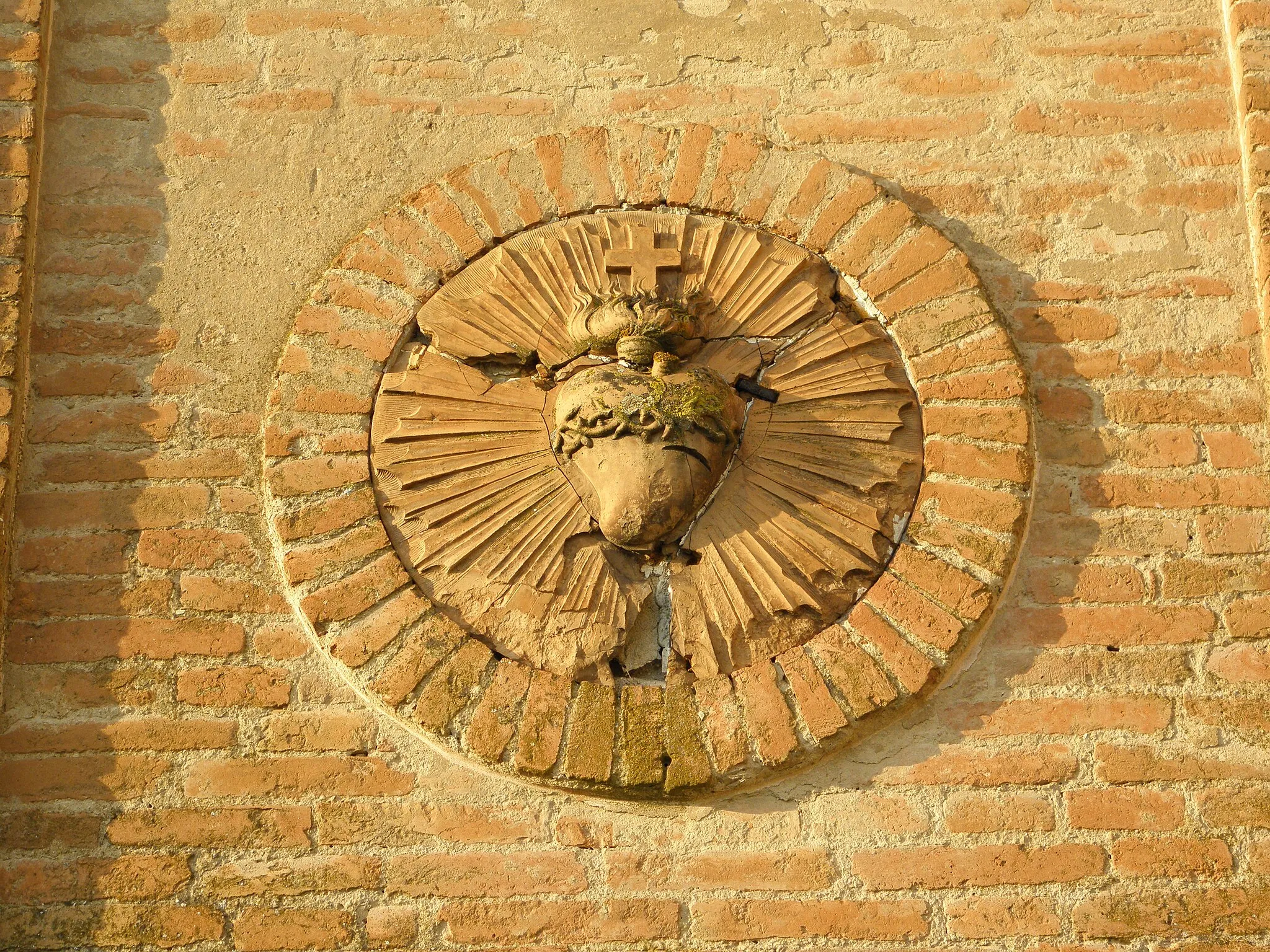 Photo showing: Spinazzino, frazione di Ferrara: dettaglio dell'altorilievo in cotto raffigurante il Sacro Cuore posto sul campanile della chiesa del Sacro Cuore di Gesù.