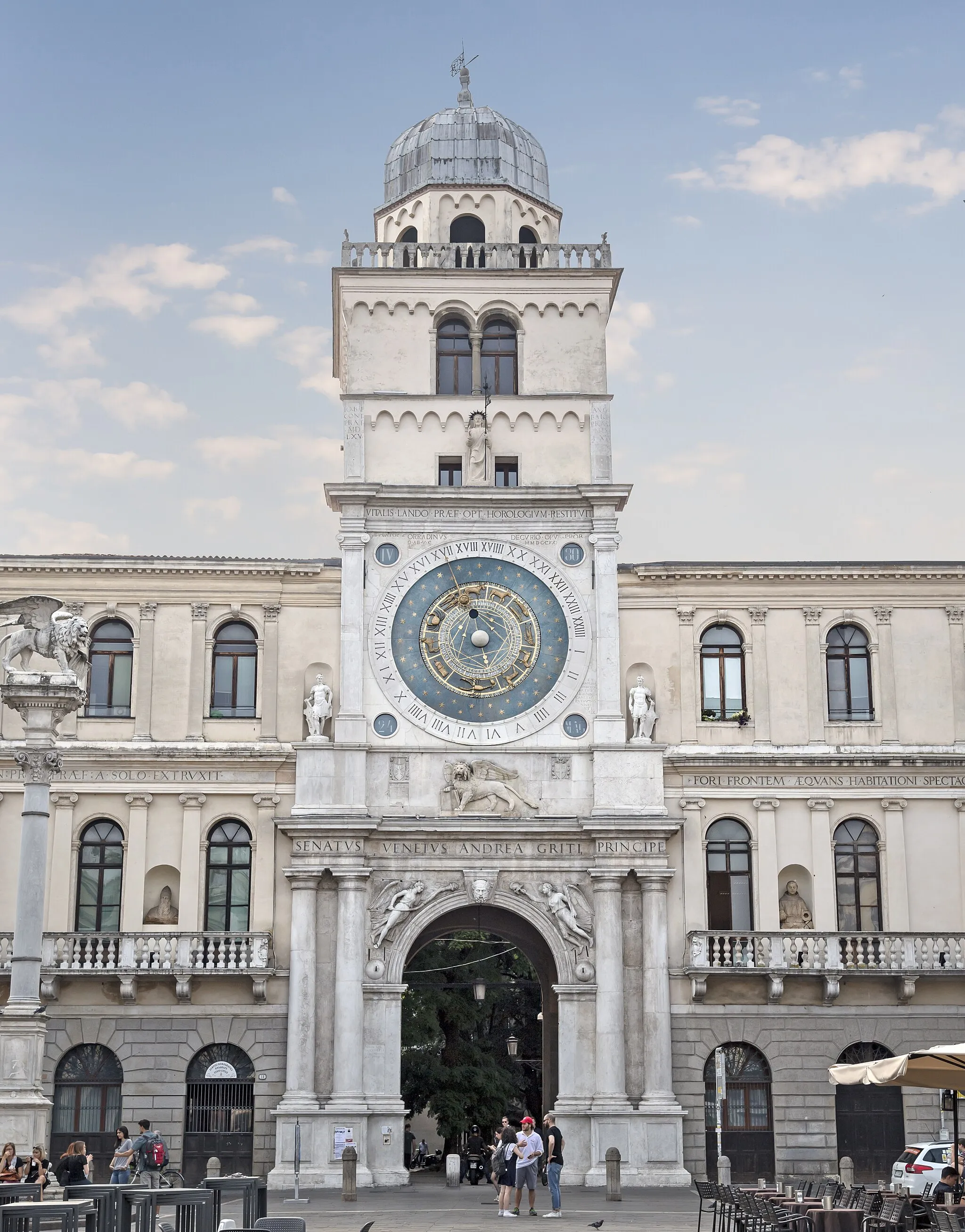 Photo showing: La Torre dell'Orologio is a building of medieval origin that overlooks Piazza dei Signori in Padua. It stands between the Palazzo del Capitanio and the Palazzo dei Camerlenghi. The tower was built in the first half of the fourteenth century as the eastern gate of the Royal Palace of Carrara. In 1428 it was raised and adorned in Gothic style and equipped with the famous astronomical clock. In 1531 the great triumphal arch was added to the base, designed by Giovanni Maria Falconetto.