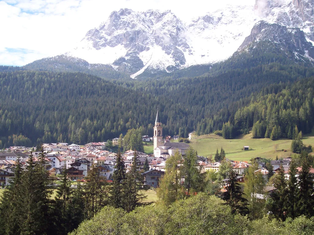 Photo showing: Padola (1215m) from 52 national street in first days of autumn 2007. Bell tower is build in 1949 with big church.
The mountains from left are:
Ajarnola 2456m, Corno di Ciapelei 2056m, Croda da Campo 2712m (not in total view).

Alls are dolomites rocks. The last mountain dolomites, near carnic alps.