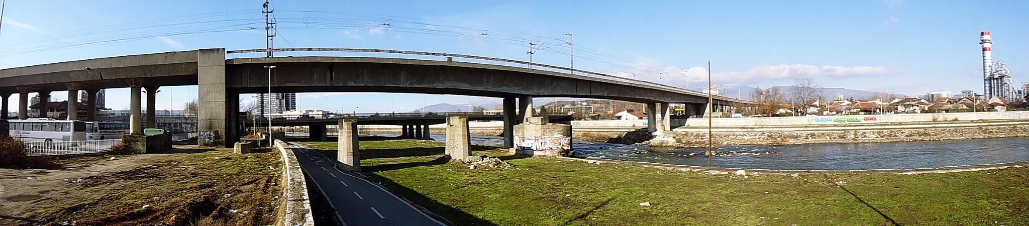 Photo showing: The rail over pass of the Main train station Skopje (the closer brigde) and Belasica Bridge (the further bridge) crossing the Vardar Рiver. The right side of the image depicts the neighbourhood of Kjeramidnica, Municipality of Gazi Baba. Photographed from the neighobourhood of Ostrovo, Municipality of Aerodrom.