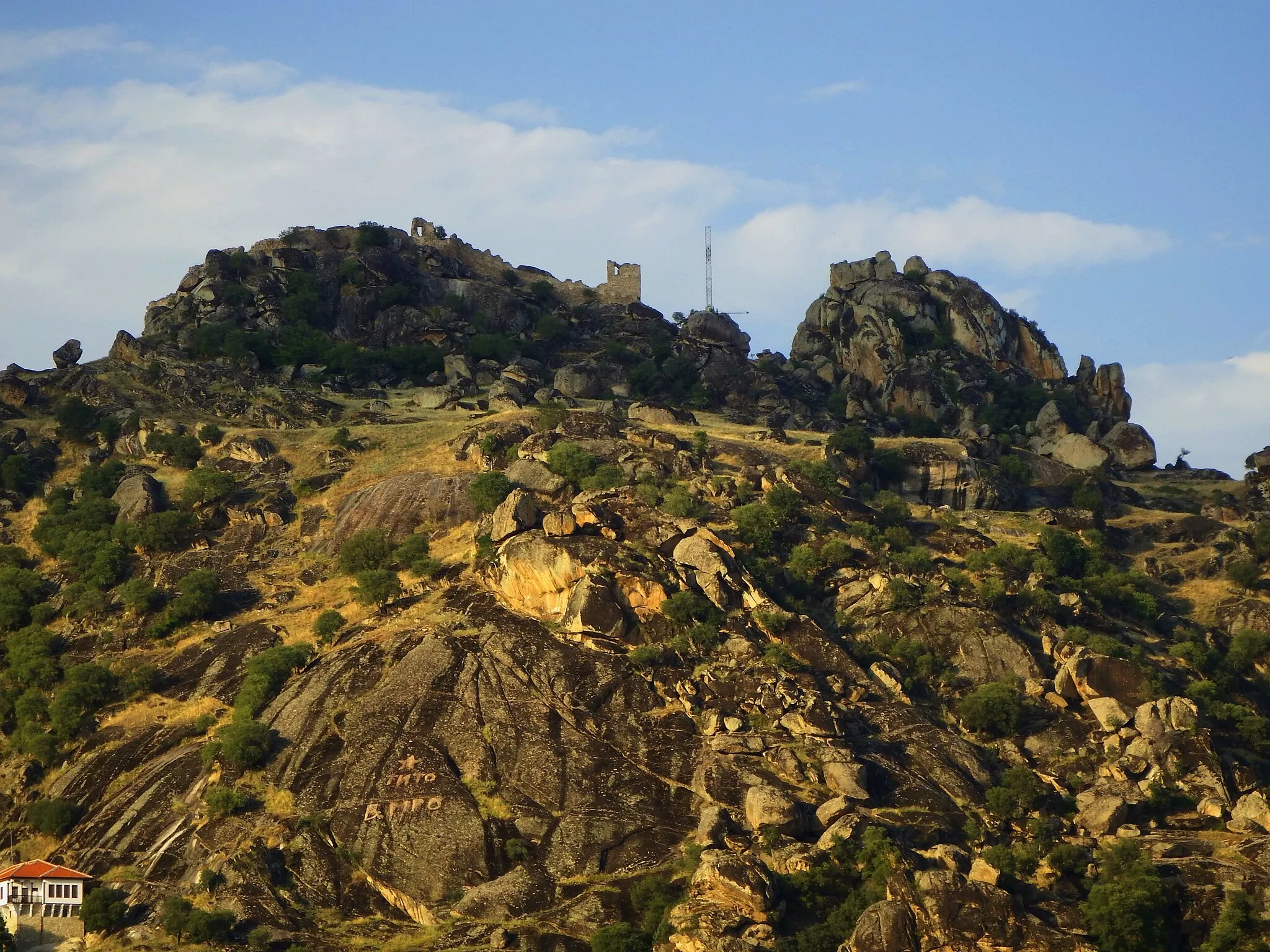 Photo showing: Markovi Kuli as the protected areas as part of the geoheritage of a granite complex, as a whole, consists of several imposing heaps connected in two parallel series with a direction of extension north-northwest/south-southeast, whose altitude gradually increases from south to north. The western range consists of the hills Markovi Kuli (945 m), Zelenik (993 m), Javi Steni (1,153 m), Zagradski Steni (1,231 m) and Marmorski Rid (988 m), while the eastern range begins with Kukul (980 m), Glavica (1,033 m), Edinok (1,303 m) and Surun (1,077 m). These two rows of mounds are separated from each other by the valley of the Dabnička River and in the northern part are connected to the highest peaks of this area - Zlatovrv (1,422 m) and Lipa (1,392 m), which stretch in a transverse direction southwest-northeast.