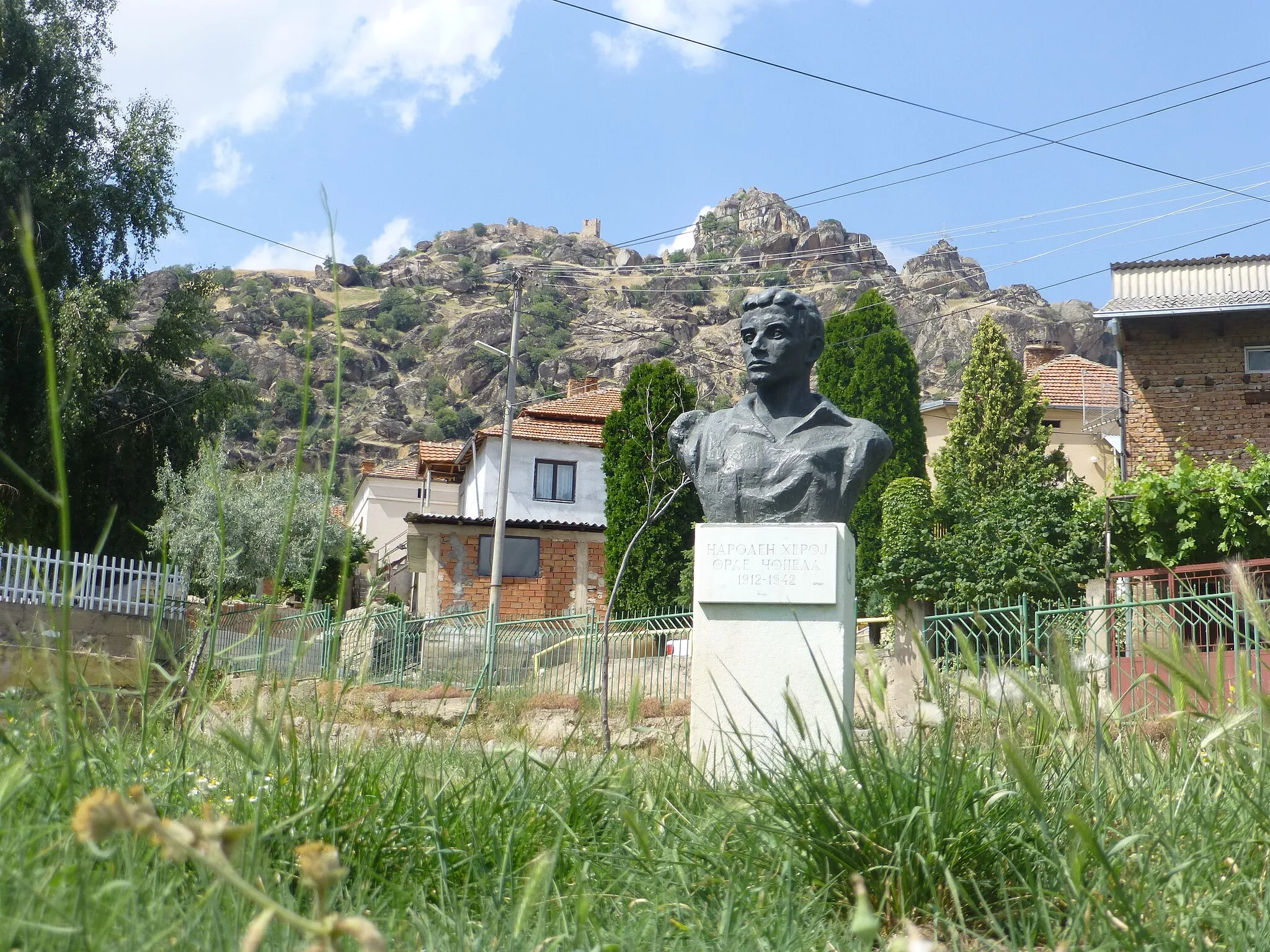 Photo showing: In the Varosh neighborhood of Prilep. A monument to a WWII resistance hero, with the Markovi Kuli in the background