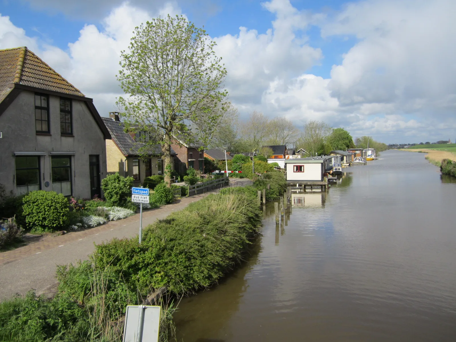 Photo showing: Ritsumazijl, county Friesland, The Netherlands. View to the east on houses and houseboats, north of the canal Zijlsterrak.