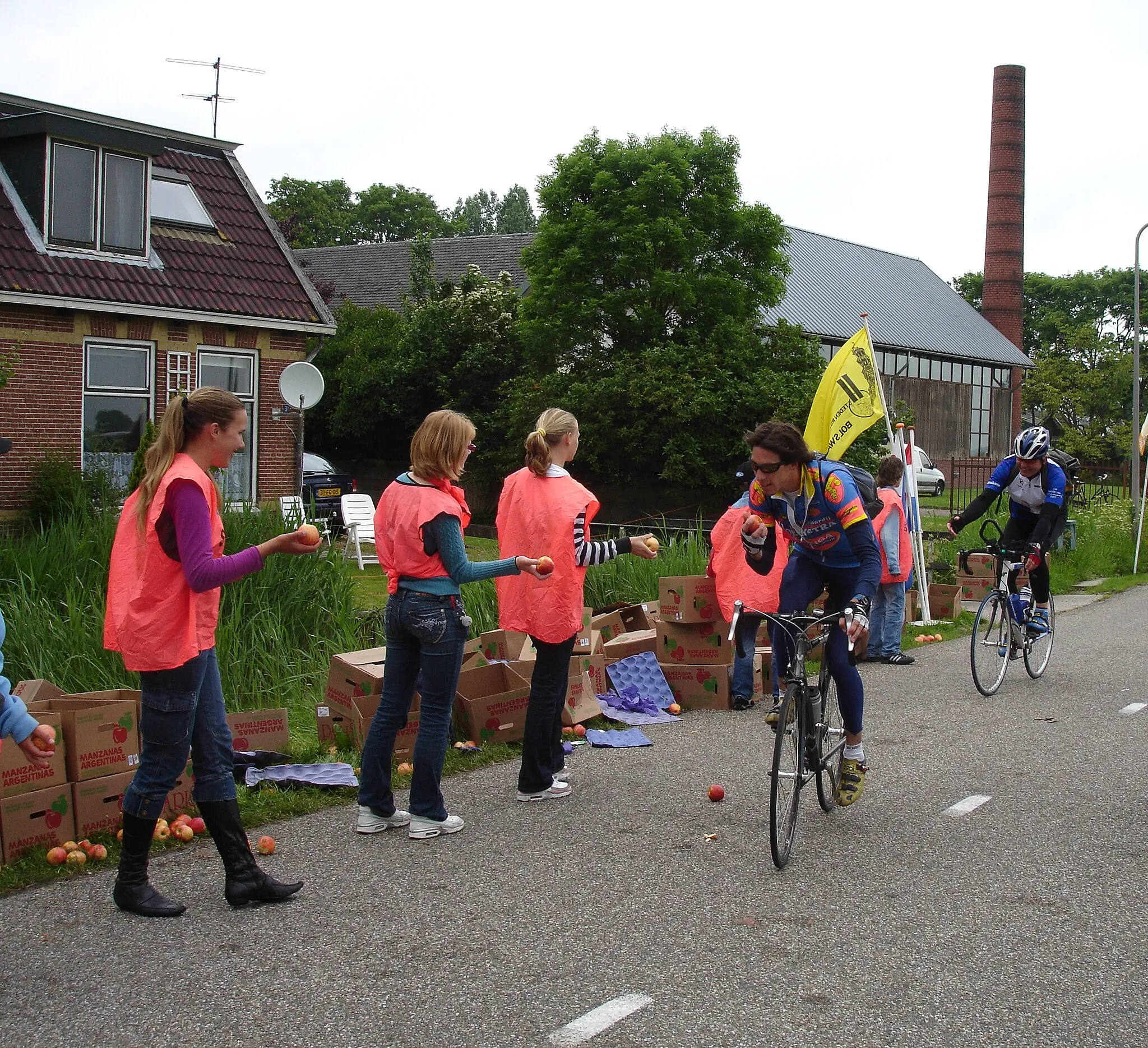 Photo showing: De deelnemers van de fietstocht krijgen appels