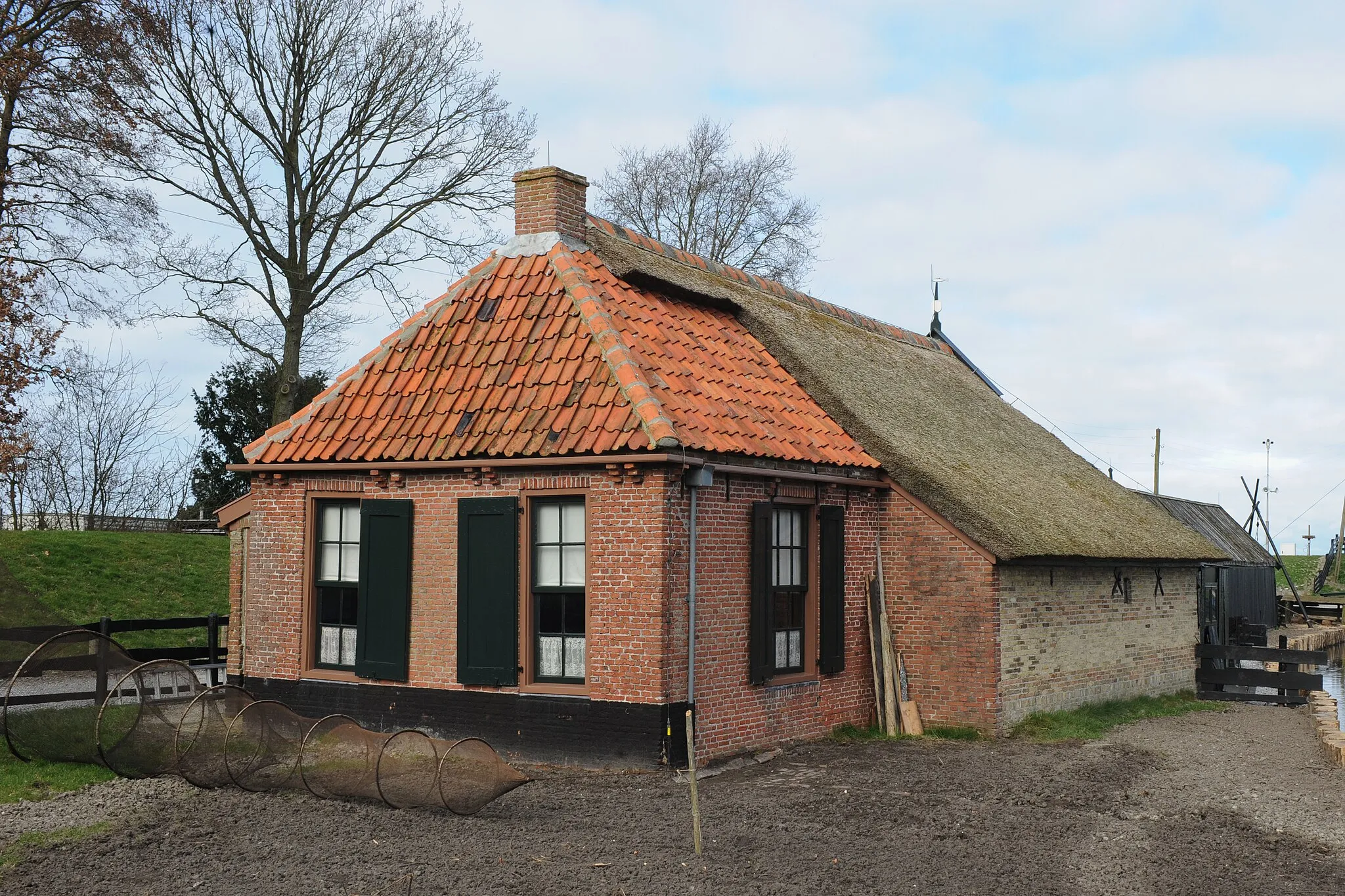 Photo showing: Vissershuis met uitgestalde fuik op de voorgrond. Foto uit 1984 in het Zuiderzeebuitenmuseum in Enkhuizen. Dit huis stond in Koehool en werd bewoonde door Heeringa.