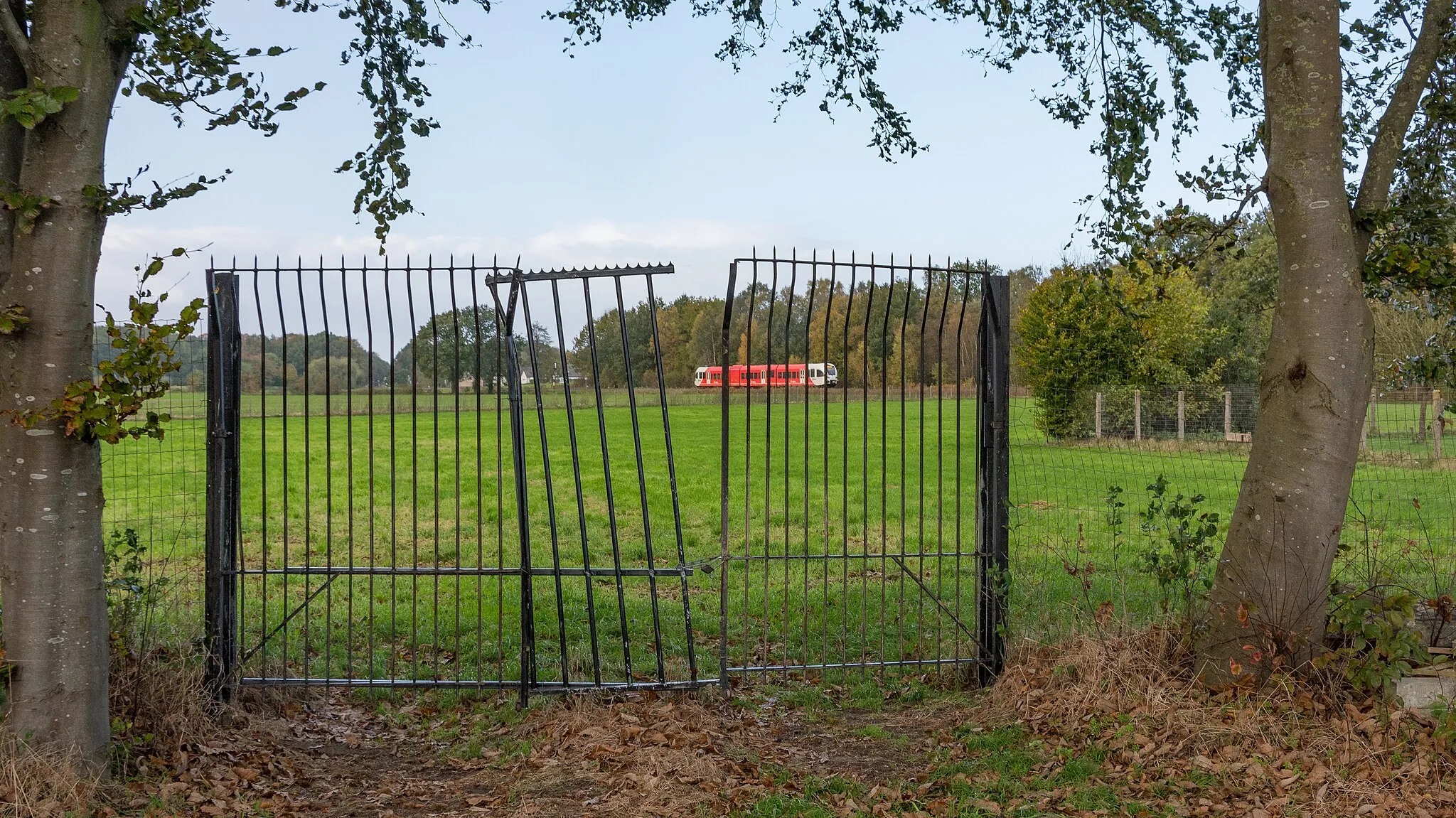 Photo showing: Tijdens mijn ritje door de Achterhoek stuitte ik op deze poort. Om de poort en de achterliggende spoorlijn met elkaar te verenigen wachtte ik op de komst van de Arriva trein, onderweg van Winterswijk naar Arnhem.