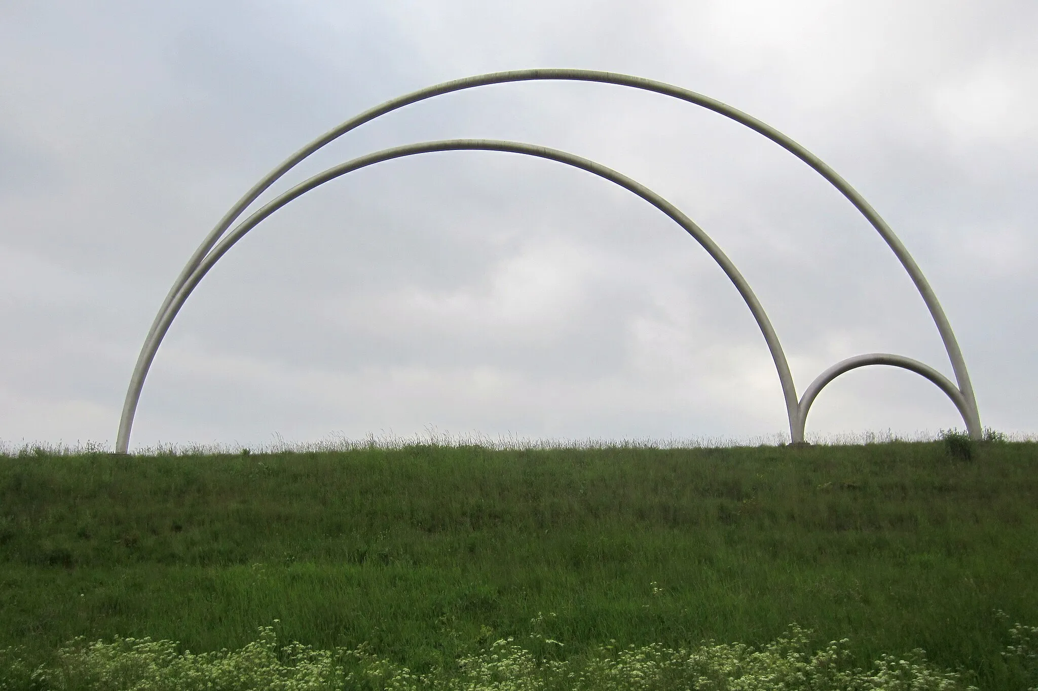 Photo showing: Arbelos sculpture in Kaatsheuvel, Netherlands. Artist: Ruud van de Ven, Best. Diameters of the three arcs (semicircles): ca. 24.2 m, 19.3 m and 4.9 m. Diameter of the profiles: ca. 32 cm. Original info board text (Dutch): see below.