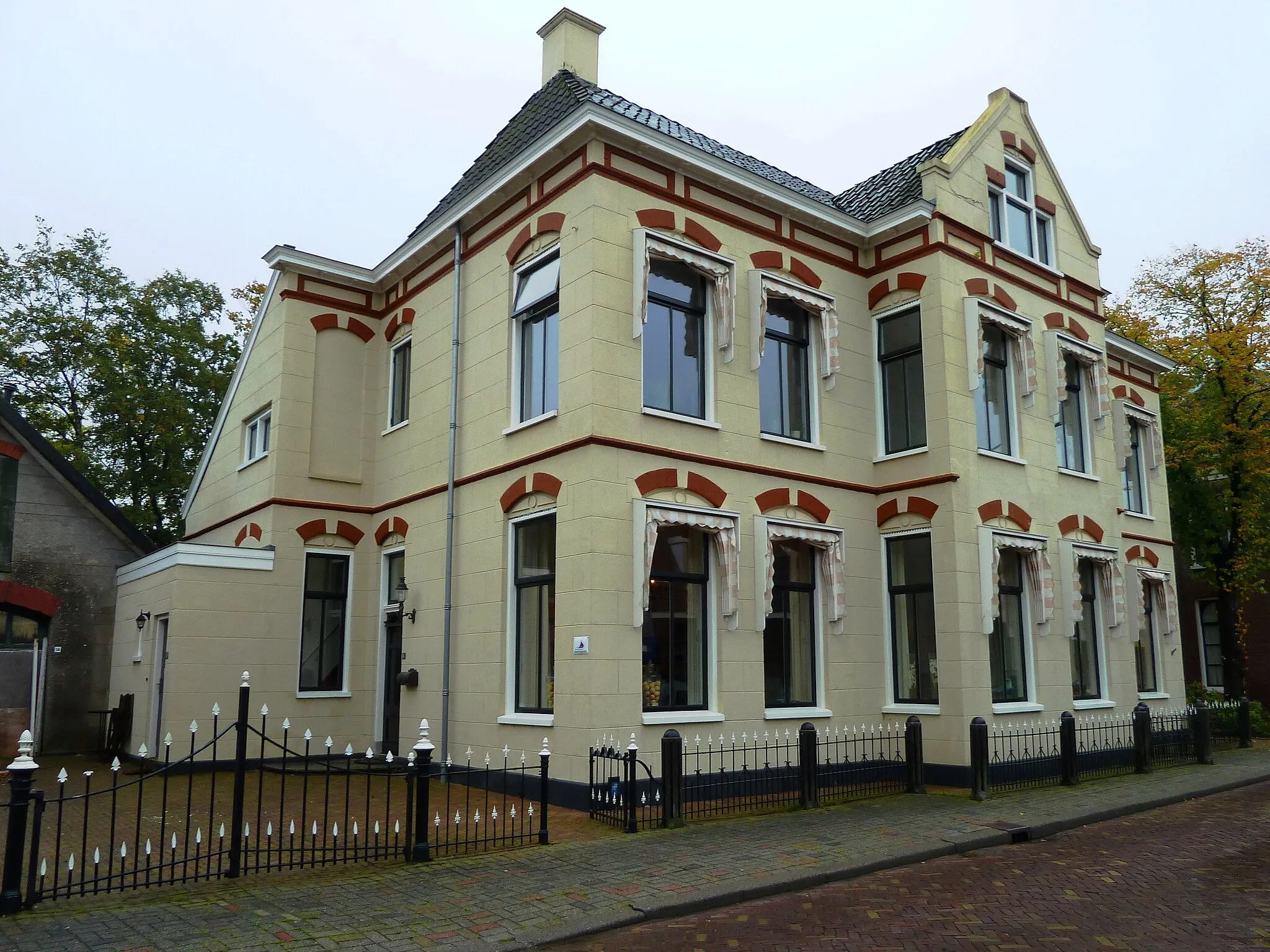 Photo showing: Herenhuis met aangebouwde stal en koetshuis op Torenstraat 14 in het Groningse dorp Scheemda. Gebouwd in 1904 in eclectische stijl met neoclassicistische elementen voor de gezusters Ter Haseborg. In 1940 verbouwd voor de huisvesting van 2 gezinnen. Had vroeger een balkon aan voorzijde. Het hek dateert ook van ongeveer 1904.