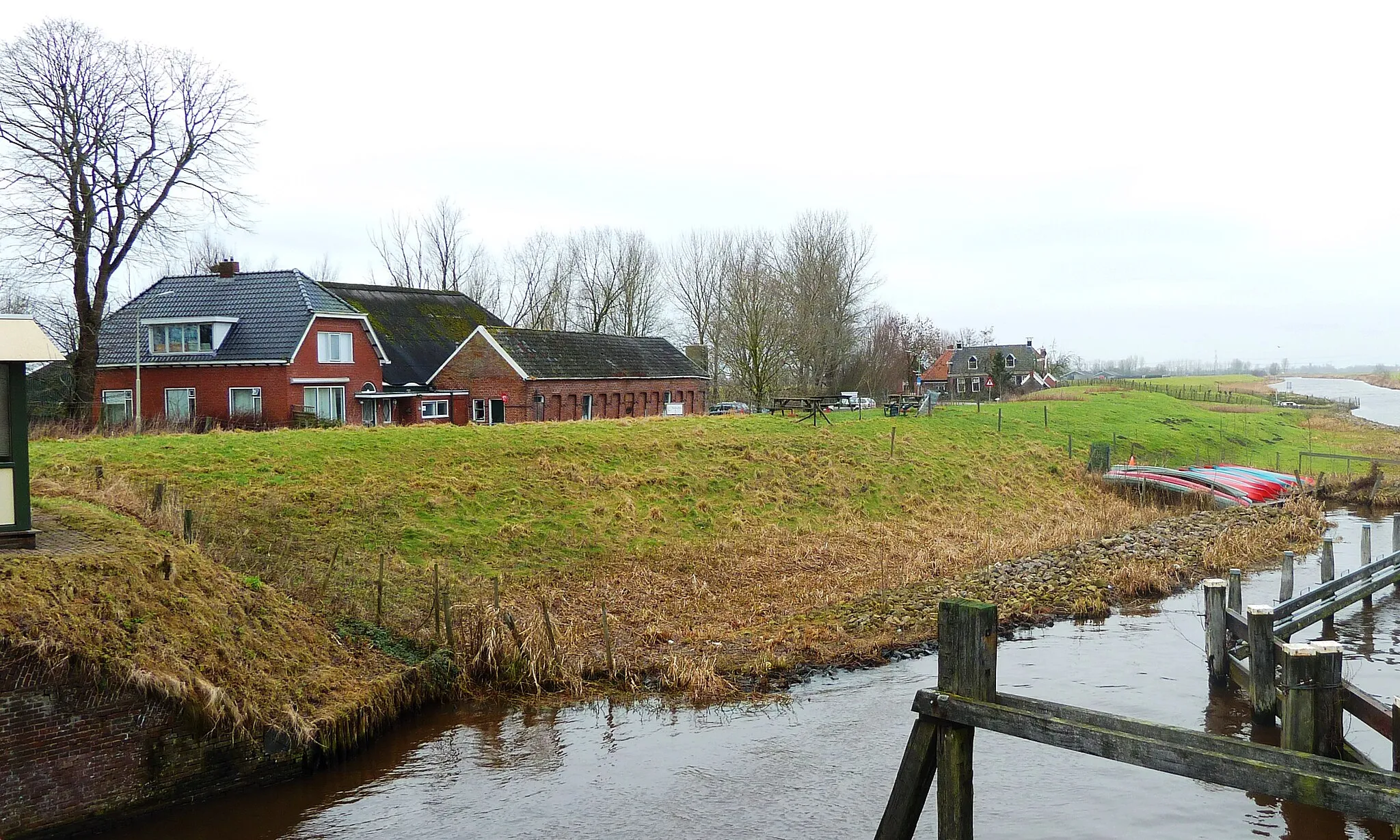 Photo showing: Huizen aan de Scholleweg in Wierumerschouw (Groningen, Nederland) gezien vanaf de brug over het Reitdiep. Liks de vroegere doorrit.