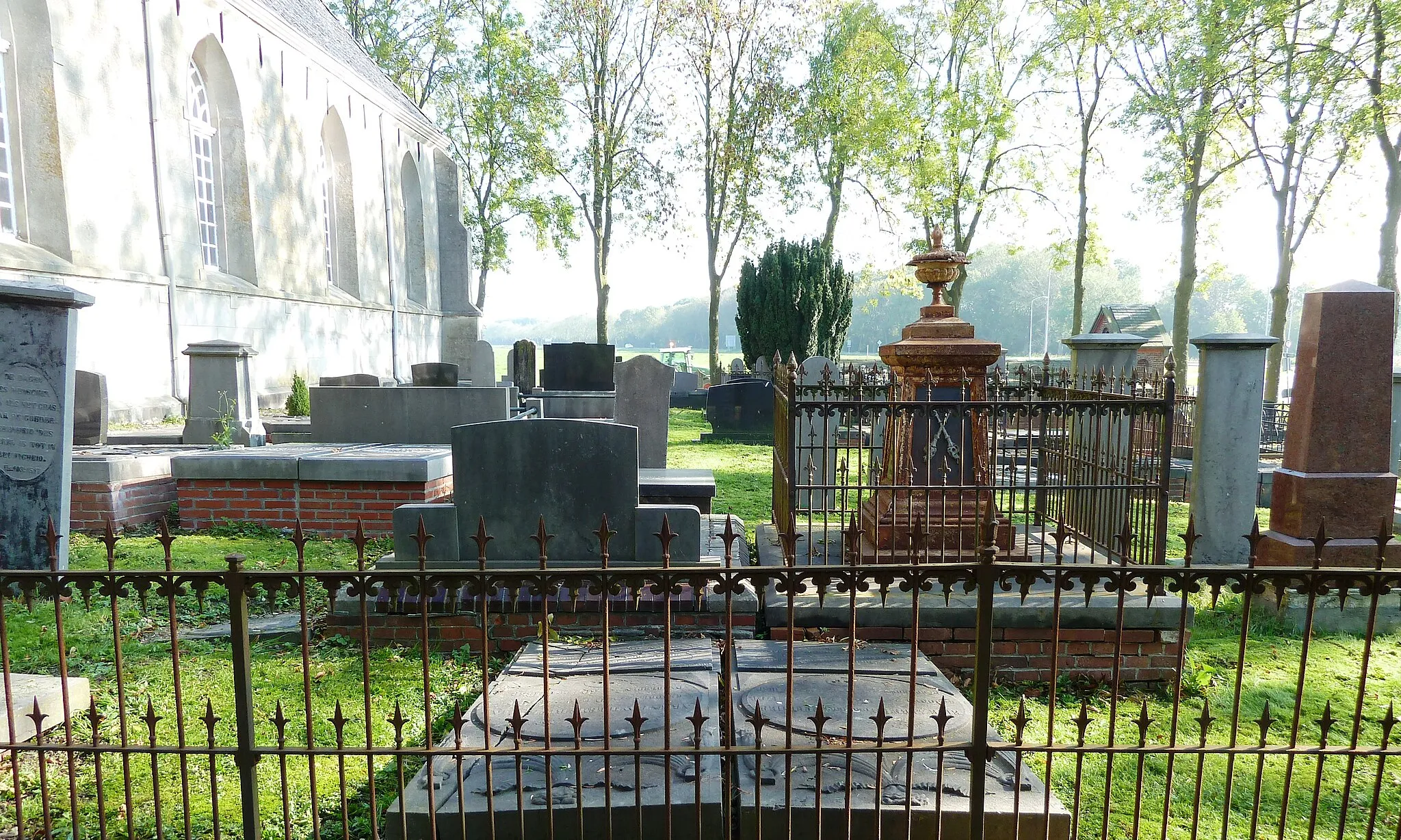 Photo showing: Begraafplaats bij de kerk van Tjamsweer. Rechts van het midden een van de gietijzeren grafmonumenten (H.D. Bos (†1898) en zijn vrouw H.J. Huisman (†1893)) die werden gegoten bij de Asser IJzergieterij van Foxham.