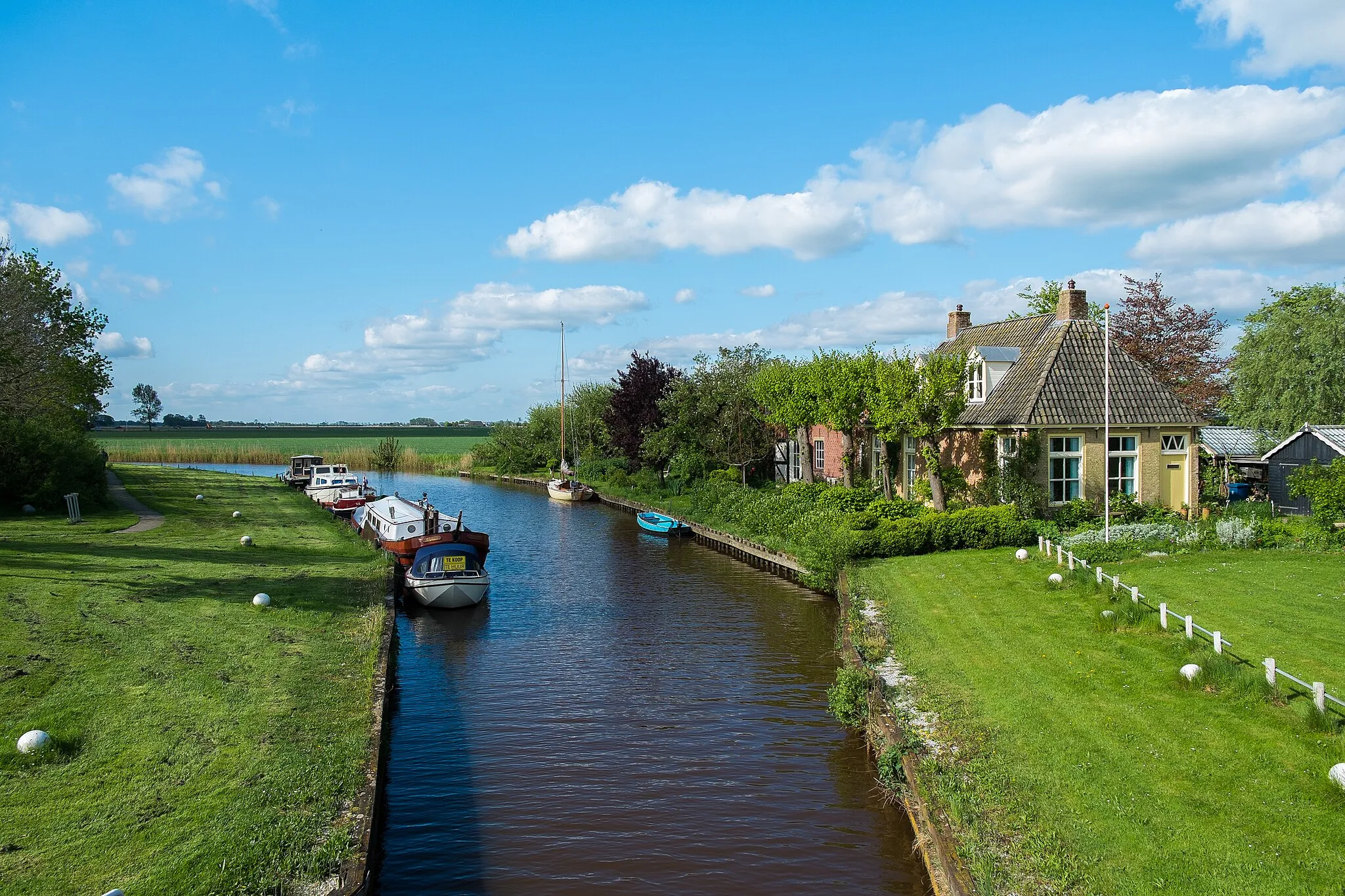 Photo showing: De Lauwers ten zuiden van de oude sluis van Munnekezijl. Links Het Eiland of De Schans; een gesloopt deel van Munnekezijl, dat nu een recreatieve functie heeft.