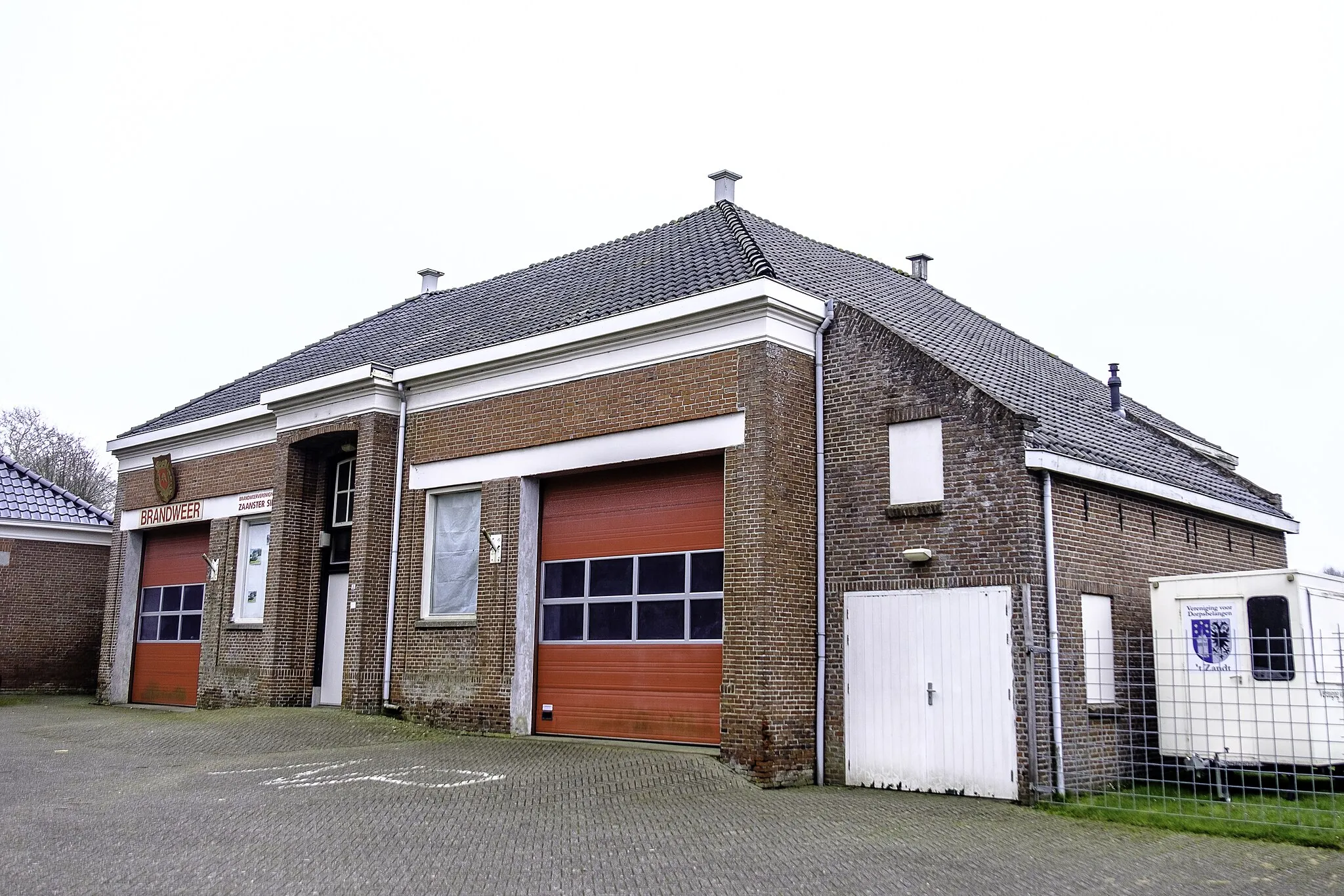 Photo showing: Oude brandweerkazerne van 't Zandt uit 1910. In gebruik tot de opheffing van de blusgroep in 2006. Sinds 2007 het onderkomen van brandweervereniging Zaanster Sik.
In 2003 werd er ingebroken door de latere pyromaan van 't Zandt die daarbij onder andere de sleutel van de deur bemachtigde. In 2007 deed hij een poging het pand in brand te steken door een kaars met brandbaar materiaal op zolder te plaatsen, maar de inbraak werd tijdig ontdekt en door hem achtergelaten sporen leidden mede tot zijn aanhouding door de politie.