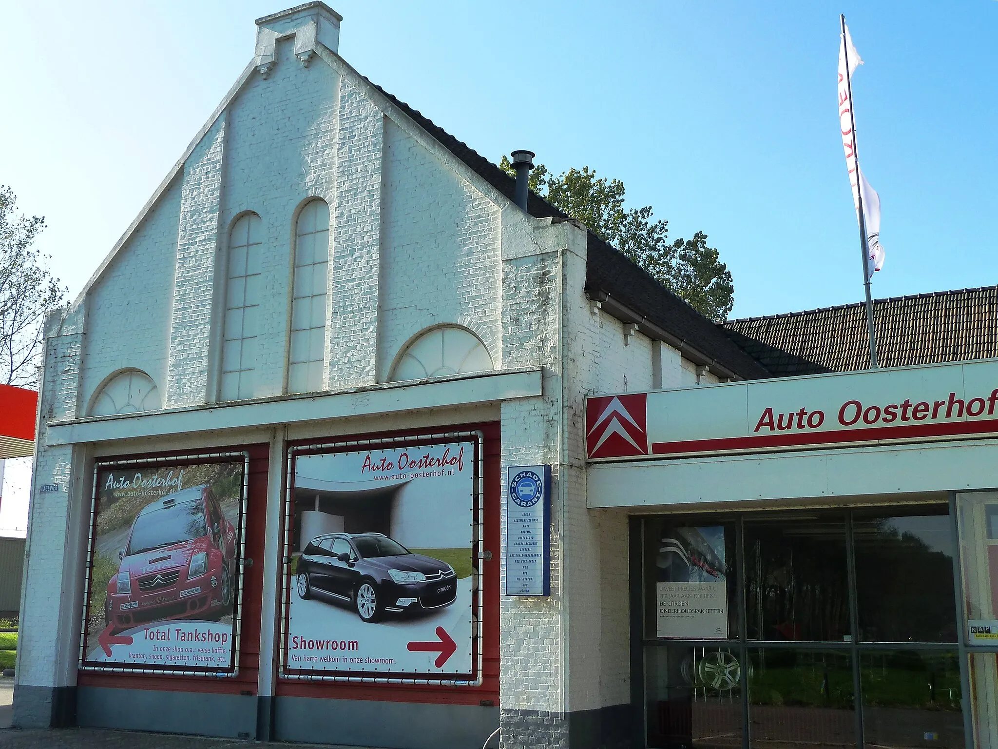 Photo showing: Voormalige gereformeerde kerk van Grijpskerk (van 1901-1938), sindsdien autobedrijf Oosterhof. Sinds 1938 in dit gebouw. Links stond vroeger de pastorie (nu tankstation), rechts de kosterij (later verbouwd tot autobedrijf.