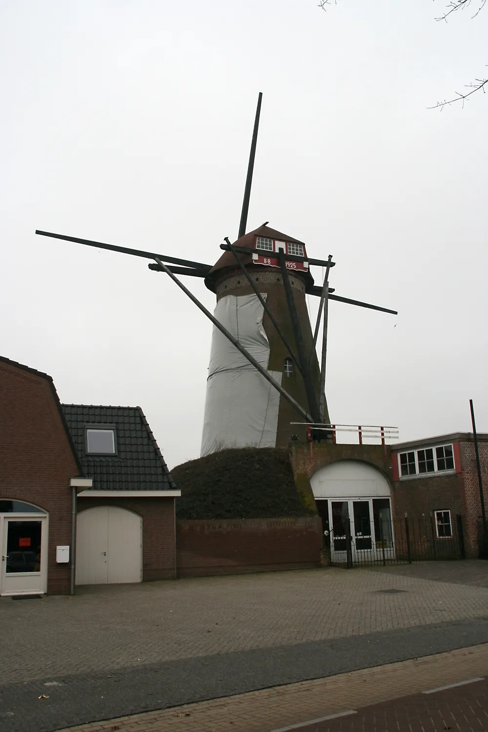 Photo showing: Maaskantje: molen De Pelikaan met kaalgezette roeden en plastic zeilen. Het lijkt in de verte wel op een huisvrouw met een schort aan