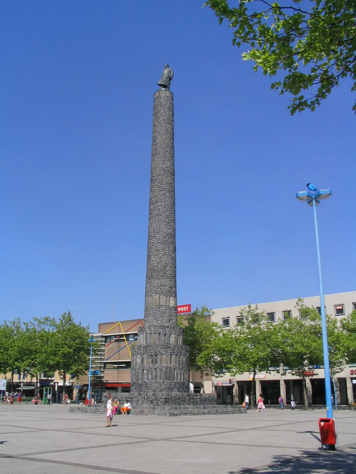 Photo showing: Zuil van Lely in het centrum van Lelystad, made by Hans va Houwelingen with a statue on top of it.The statue is the same one that stands at Den Oever and was originally made by Mari Andriessen.