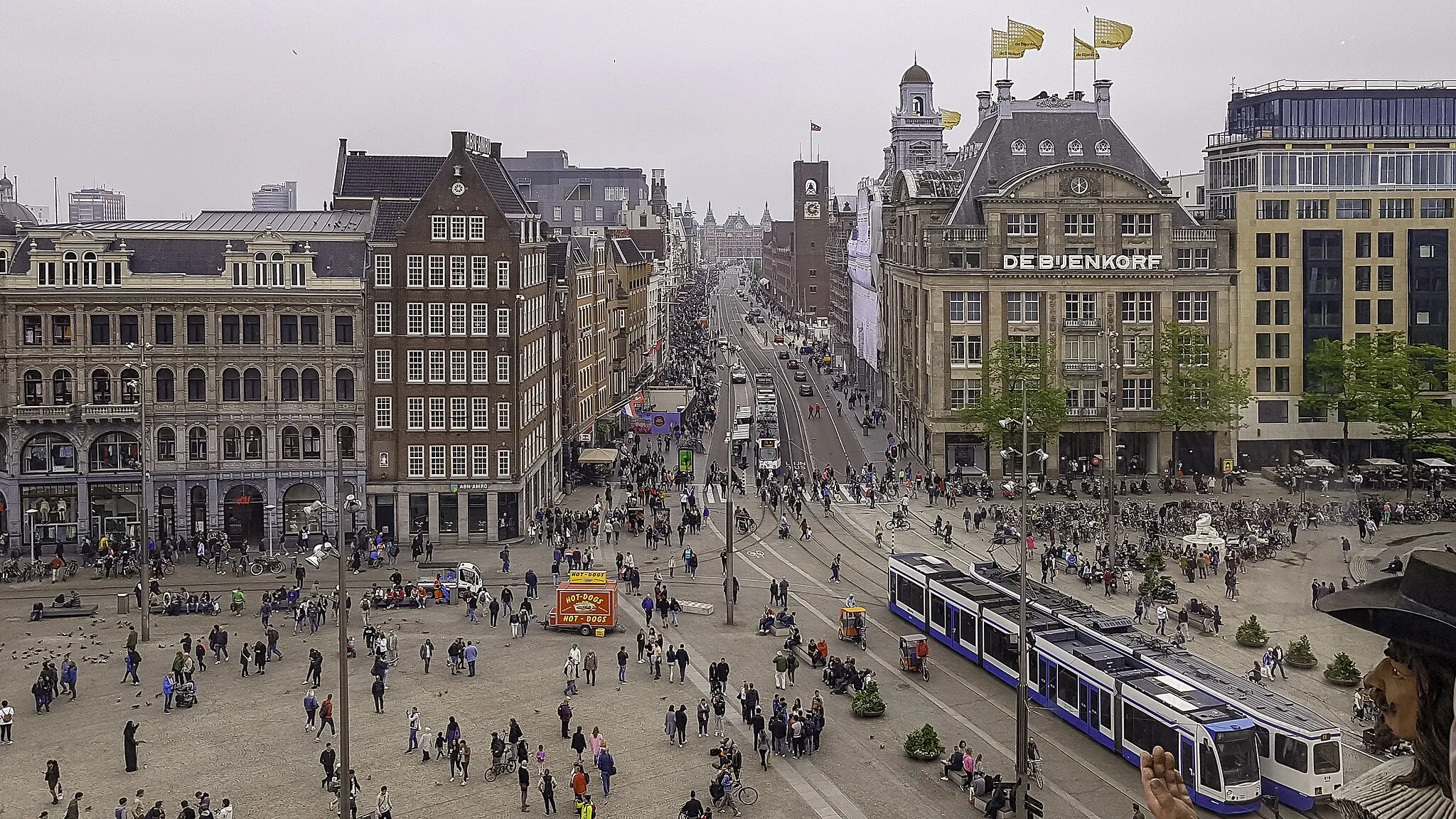 Photo showing: Overzicht over de Dam in Amsterdam met al haar drukte. Links langs warenhuis de Bijenkorf over het Damrak kom je dan uit bij het Centraal Station