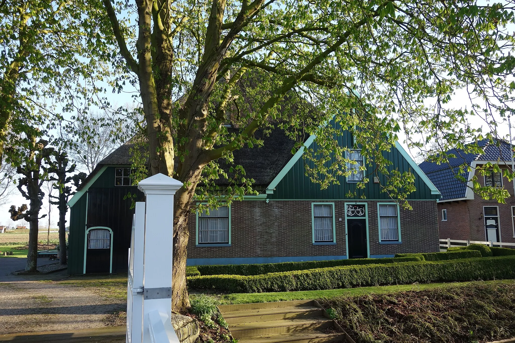 Photo showing: Stolphoeve met houten top rechts op de voorgevel. Bewerkt bovenlicht boven de rouw- en trouwdeur.