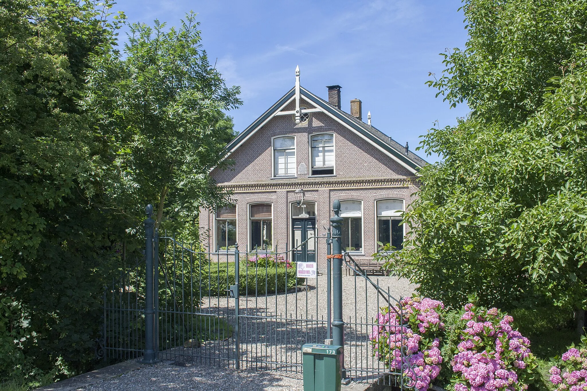 Photo showing: Vrijstaande voormalige PASTORIE, behorend bij de laat 17de-eeuwse kerk van St. Maartensbrug (adres: Grote Sloot 233) die reeds rijksbescherming geniet en in het register is opgenomen onder monumentnr. 41938. De in ambachtelijk-traditionele bouwtrant uitgevoerde pastorie is gelegen aan de westzijde van de Grote Sloot en is ten opzichte van de Grote Sloot teruggelegen. De pastorie werd gebouwd in 1880, de aannemer was P. Wilms. De pastorie is omstreeks 1988 gerestaureerd, waarbij onder andere de topgevels met makelaars en de zonnerakken in de voorgevel werden teruggebracht. De pastorie is tegenwoordig (1995) in gebruik als particulier woonhuis.