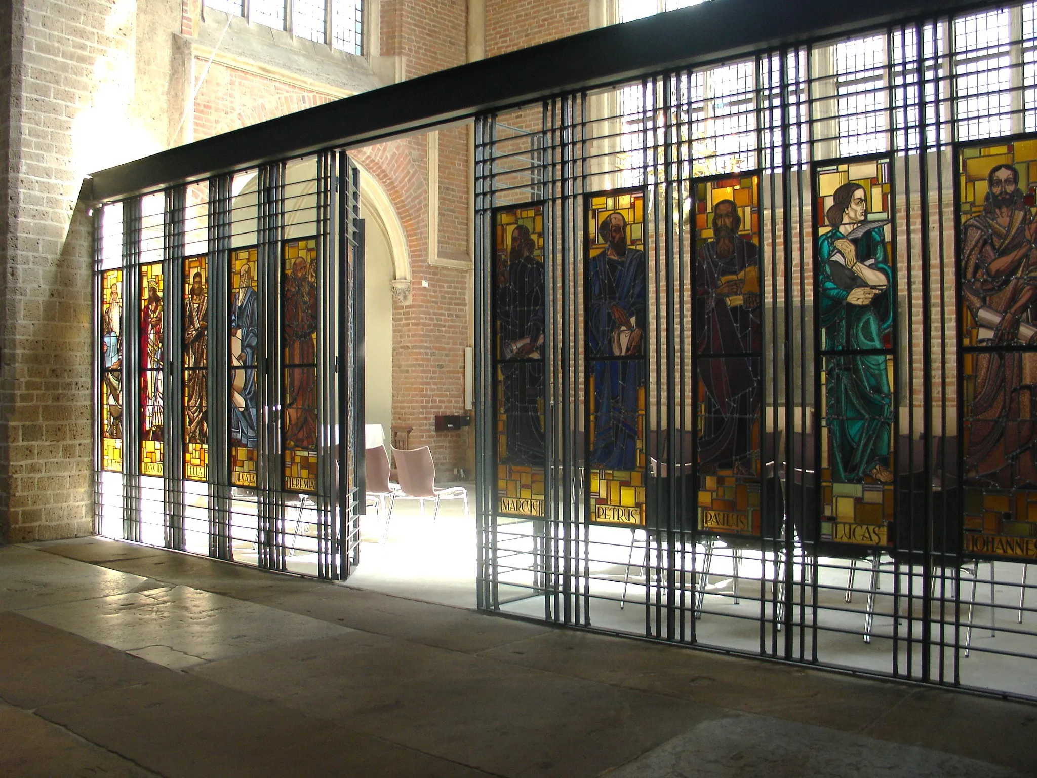 Photo showing: In 2012 geplaatste glas-in-lood afscheidingswand van de Magistraatskapel in de Lebuinuskerk in Deventer. De glazen in expressionistische stijl komen uit de voormalige gereformeerde kerk in de Smedenstraat te Deventer die in 1935 werd gebouwd. Makers zijn de Haarlemse glazeniers Nico Schrier en Huib de Ru.