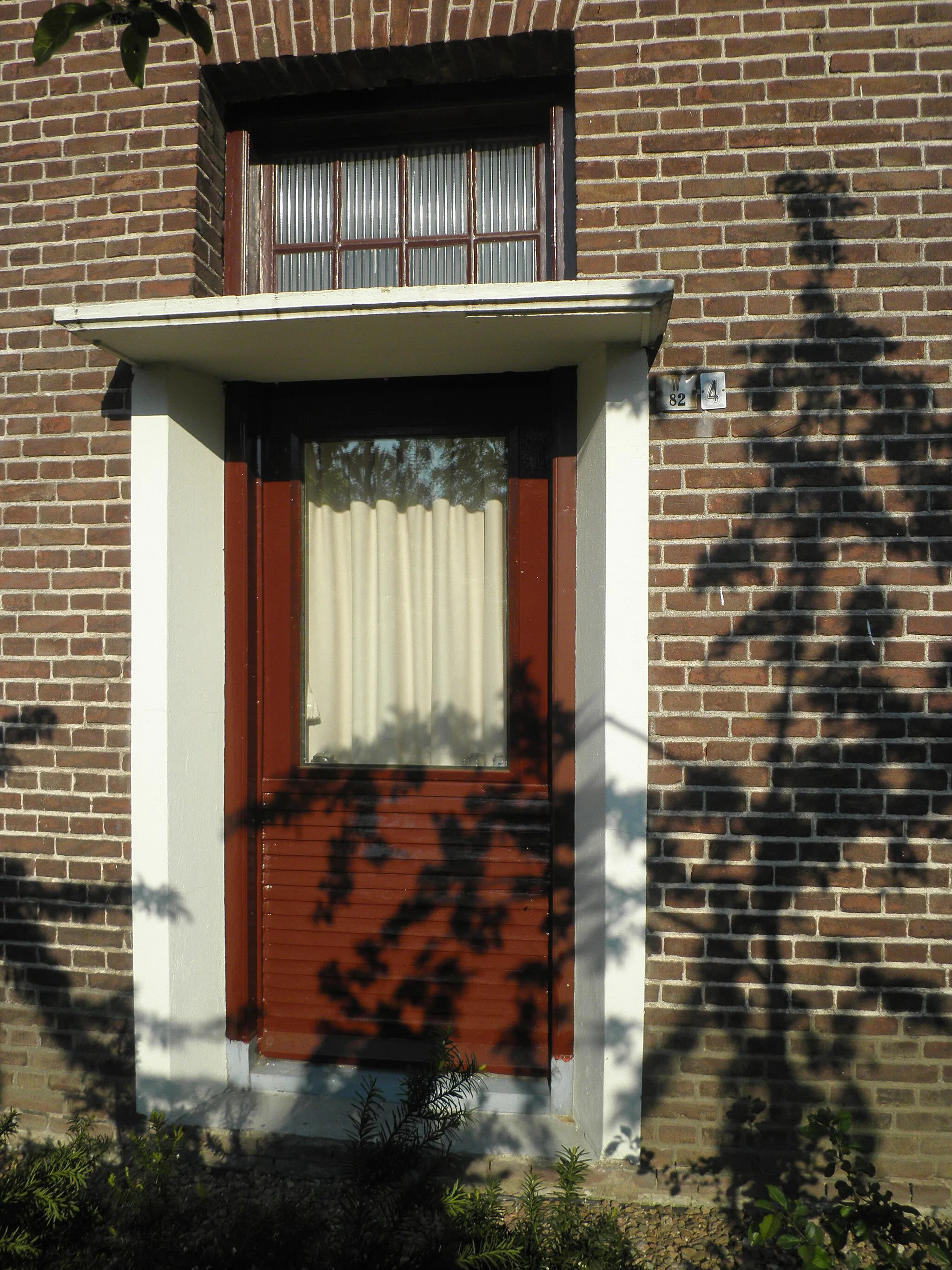 Photo showing: Former front door of house showing signs with both the present number 4 in street and the historical number W 82 in Weteringen neighbourhood
