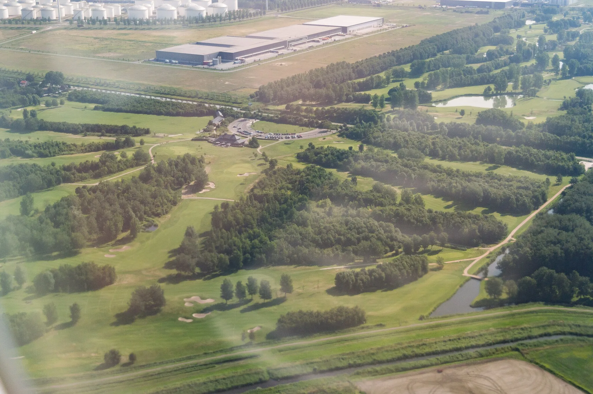 Photo showing: An aerial photograph of the golf course Houtrak and its club house. The picture was taken inside an aircraft.