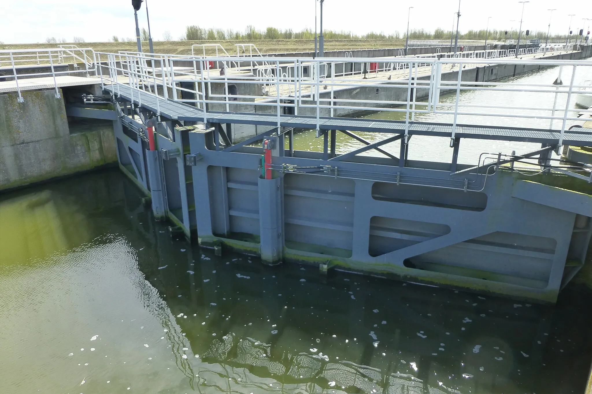 Photo showing: Naviduct (a road unterpassing a navigation lock) near Enkhuizen, the Netherlands: a set of steel mitre gates in the western lock