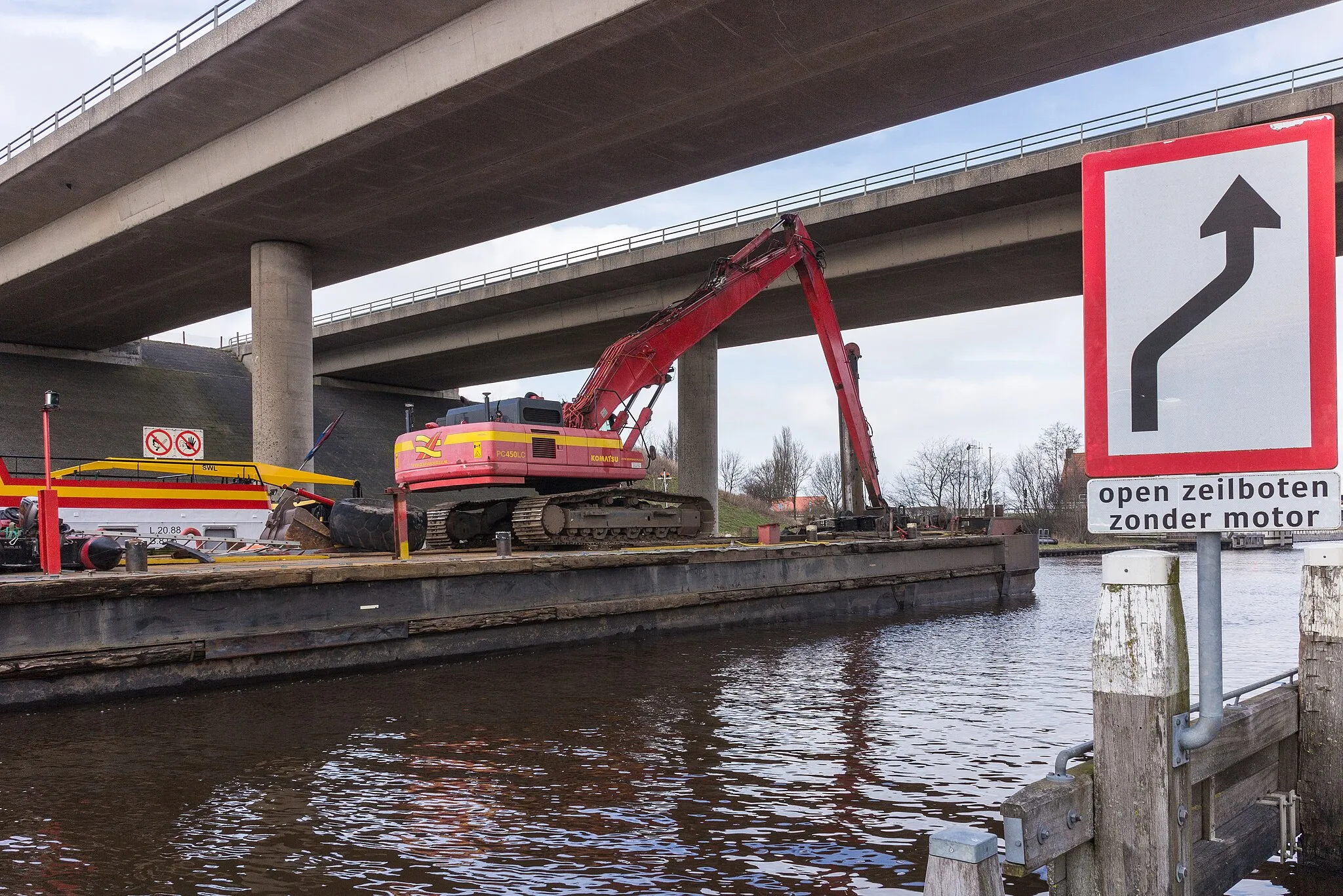 Photo showing: Dredging activities on the Langwarder Wheels. Motor cargo ship Hector sails with Komatsu crane PC450LC under the bridge in the A7.