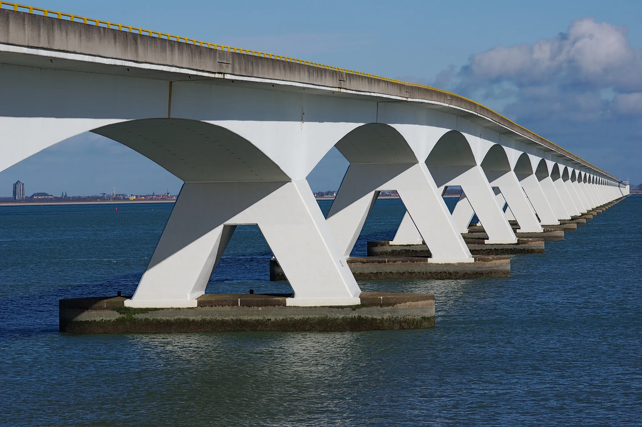 Photo showing: 500px provided description: en.wikipedia.org/wiki/Zeeland_Bridge
This brigde is 5 km long, when it was built in 1965 it was the longest bridge of Europe. This image shows almost the full length of the bridge, as seen from the south (Colijnsplaat). Through the first span you can see the "fat tower" of Zierikzee on the other side of the Oosterschelde.

en.wikipedia.org/wiki/Sint-Lievensmonstertoren [#bridge ,#pier ,#waterfront ,#dock ,#waterway ,#Zeeland ,#Netherlands ,#Zeelandbrug ,#Zierikzee ,#water-front ,#Colijnsplaat]