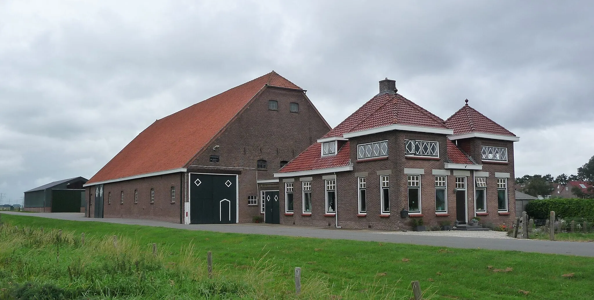 Photo showing: Boerderij Saarloos (1926) Hekelingen. Boerderij "Saarloos" is gebouwd in 1925. Hij is van het type zijlangsdeelboerderij. Bij een zijlangsdeelboerderij ligt het woonhuis uit het midden tegen de voorzijde van de schuur, waardoor er plaats is voor een zogenaamde “inrij” naar de schuur. De eerste steen werd op 15 juni 1925 gelegd door Arie Saarloos. Bron: https://mooispijkenisse.wordpress.com/2013/10/21/boerderij-westdijk-15/. Meer informatie: https://mooispijkenisse.wordpress.com/2013/12/02/boerderij-saarloos-westdijk-15-deel-2/