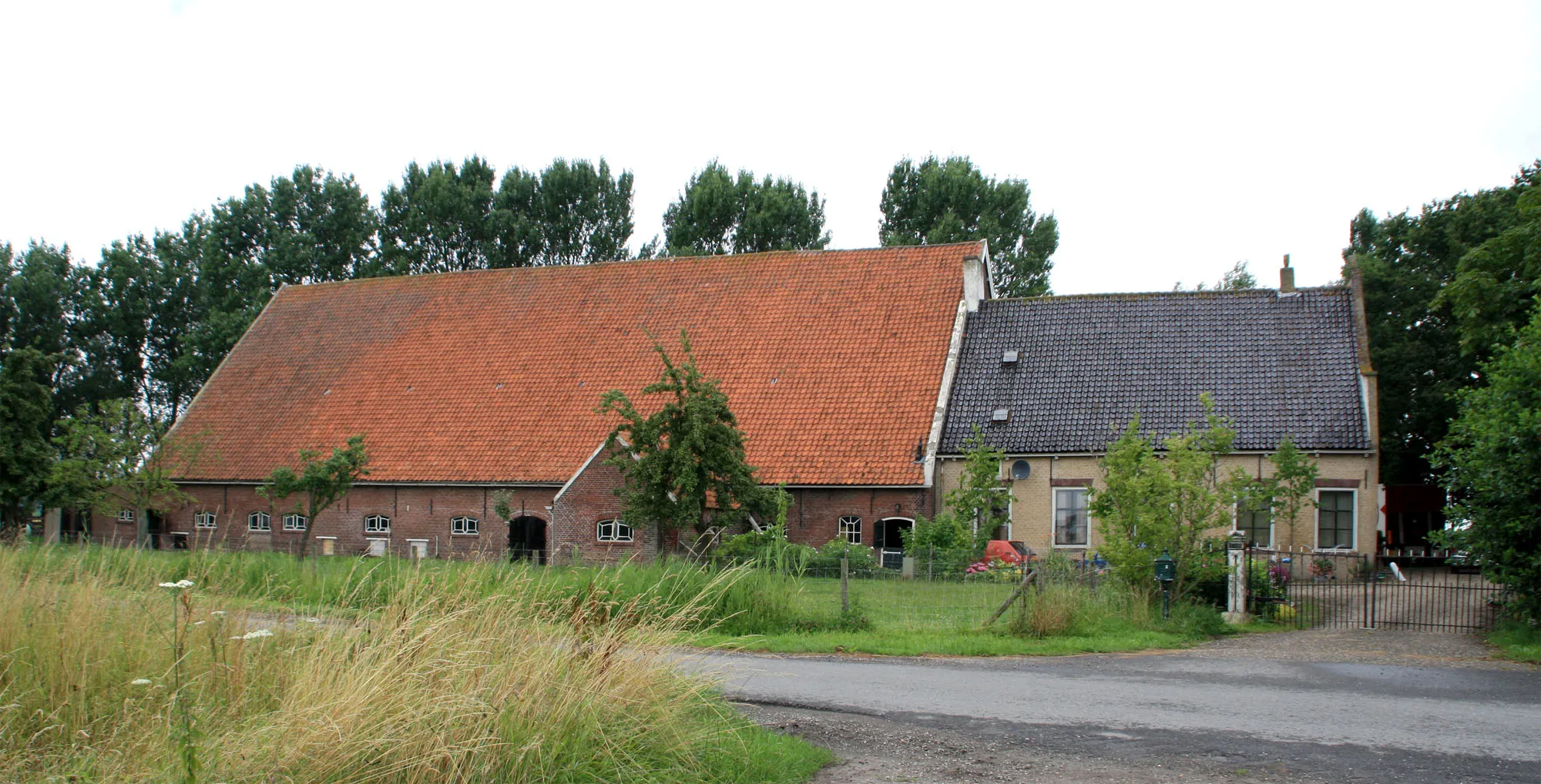 Photo showing: Hoeve Waterrijk (1816), Breeweg 2 Nieuwenhoorn (Gemeente Hellevoetsluis). Rijksmonument nr: 21436. Boerderij van het middenlangsdeeltype van de Vlaamse schuurgroep, gedateerd in de geveltop 1816. Het woonhuis heeft een gevel met ingezwenkte zijkanten. De stal is later in de 19e eeuw vernieuwd. Beide worden gedekt door pannen zadeldaken.