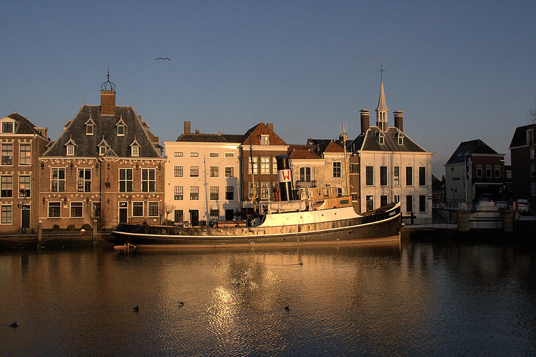 Photo showing: Maassluis: Furie aan de kade met monumentale panden aan de Hoogstraat op de achtergrond. Links staat de vormalige Gemeenlandshuis van Delfland, Delflandshuis. Rechts de Wateringsesluis. Geheel rechts het Raadhuis.