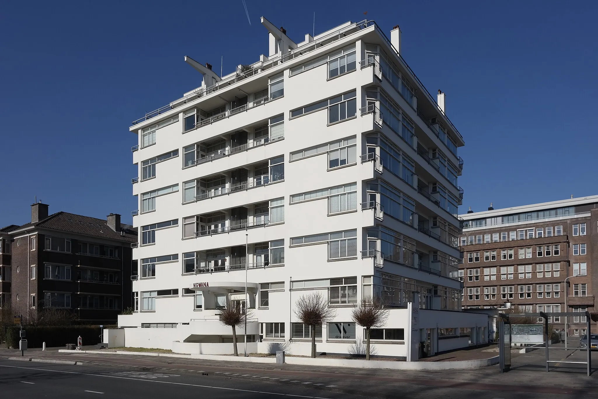 Photo showing: Nirwana-flat naar een ontwerp van architecten J. Duiker en J. Wiebenga uit 1926. Op de achtergrond bevind zich het oude gebouw van de Octrooiraad op het Willem Witsenplein nr 6.