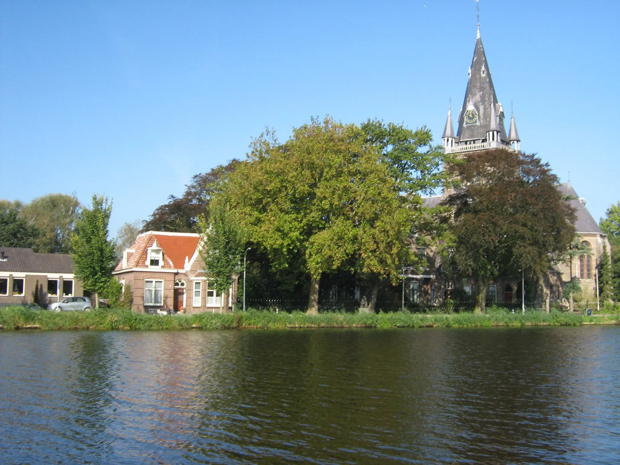 Photo showing: View of Nes aan de Amstel, a village in the municipality of Amstelveen, the Netherlands. The water in the foreground is the river Amstel. Photograph taken from the east on October 6 2007 by the uploader, who has donated it to the public domain.