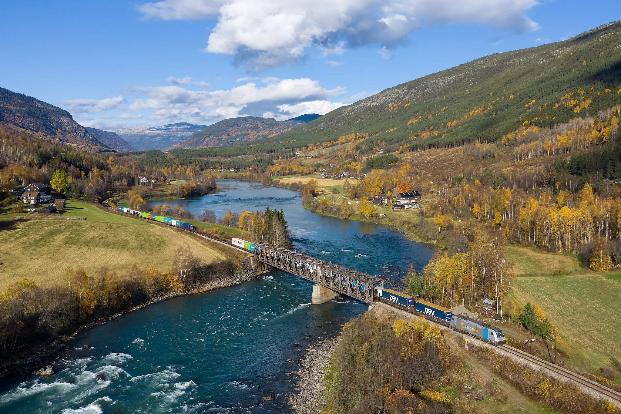 Photo showing: An intermodal freight train hauled by a CargoNet class 185 "Traxx" crosses the Gudbrandsdalslågen between Kvam and Sjoa, Norway.