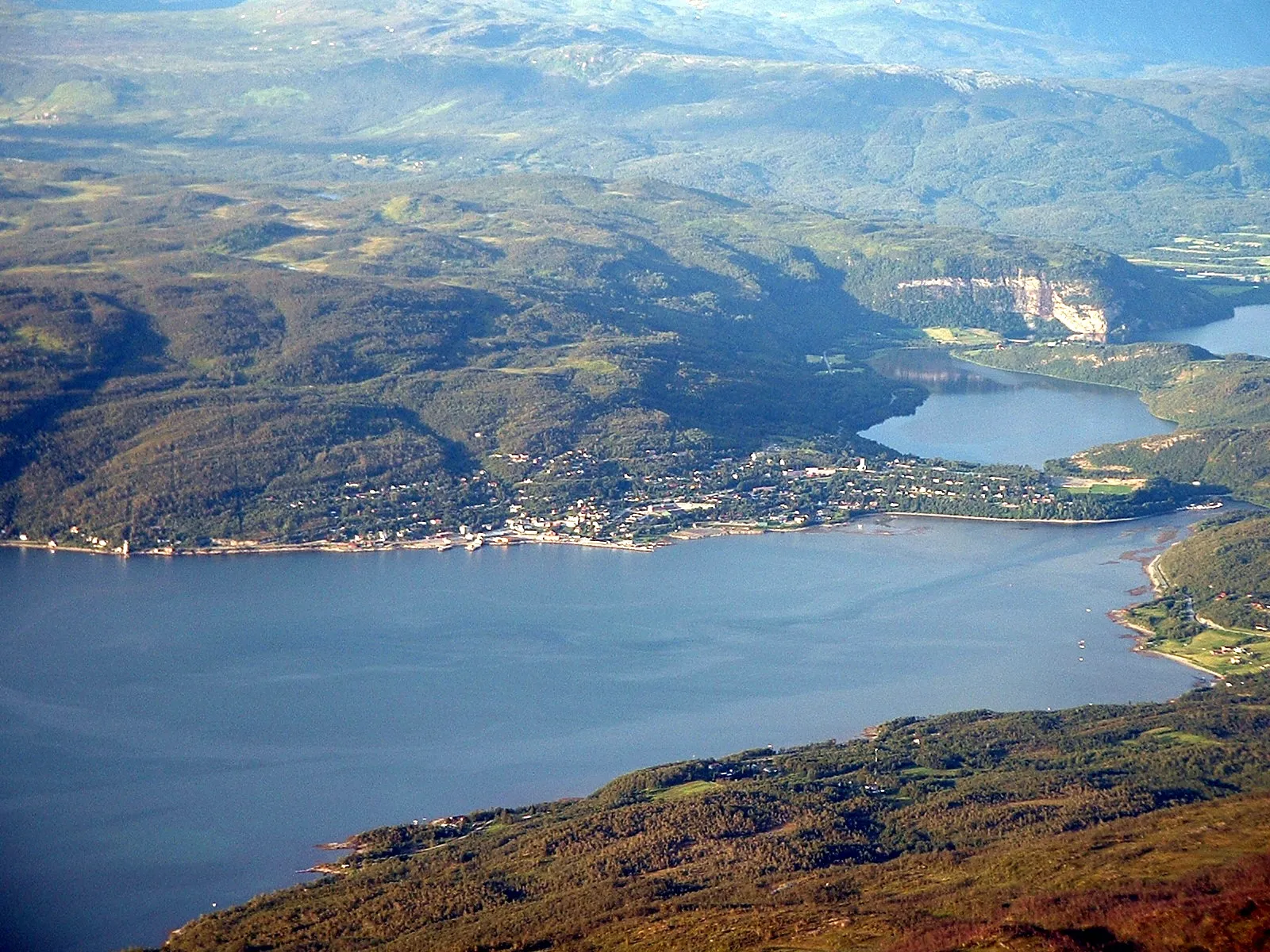 Photo showing: The picture shows Sjøvegan, the administrative centre of Salangen municipality in Troms county in Norway, and the surrounding areas. The inner part of the Salangen fjord, Sagfjorden lies in front of Sjøvegan, and to the right Nervatn and a part of Øvervatn is visible. The picture is taken from Høgfjellet, the second highest mountain in the municipality, more than 1200 metres above sea level.