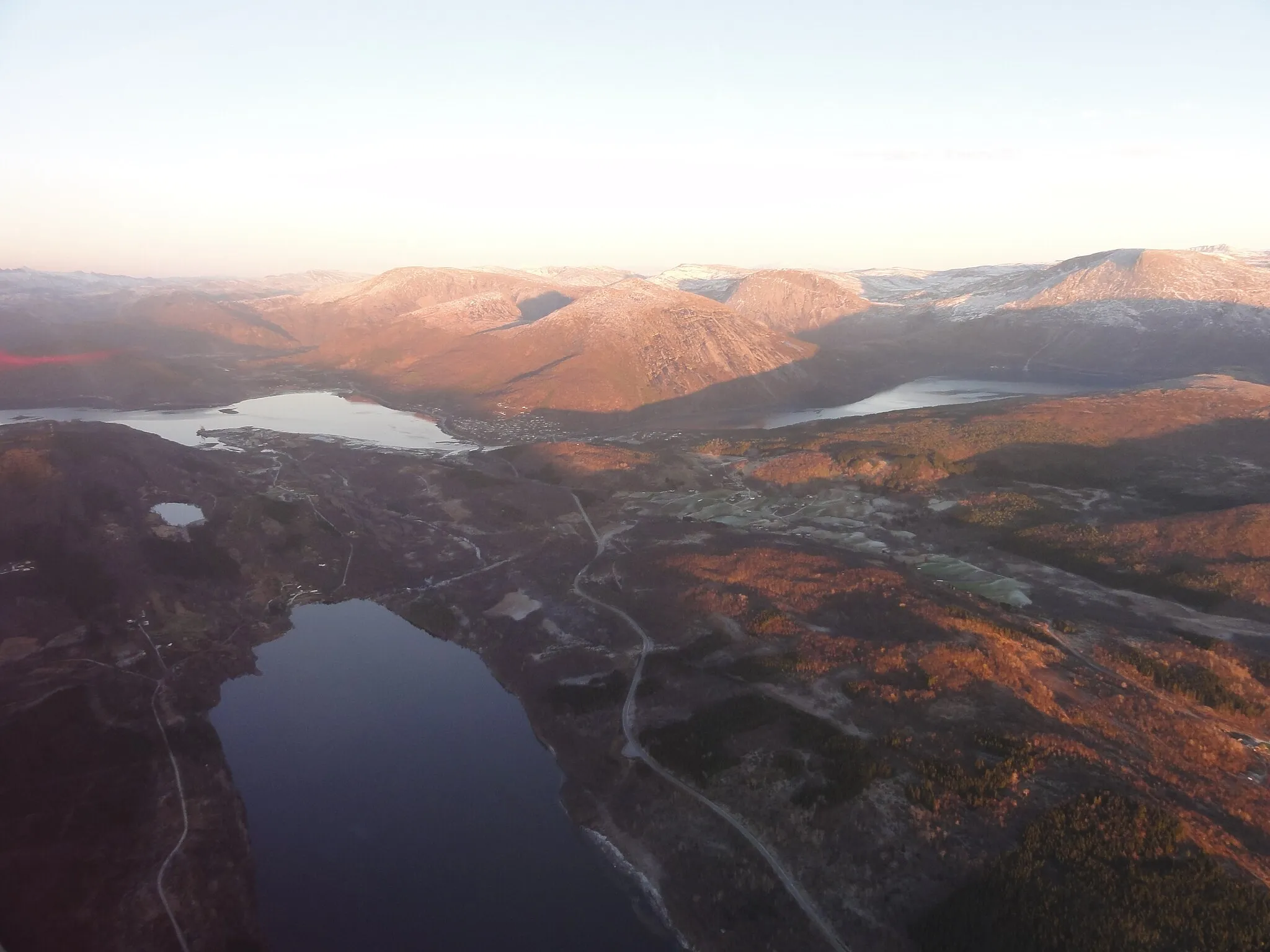 Photo showing: Straumen omentrent midt i bildet og ligger i enden av fjorden Sørfolda. I forgrunnnen sees Vallvatnet. Straumen er administrasjonssenteret i Sørfolda kommune i Nordland. Salten verk kan skimtes ut mot fjorden helt til venstre i bildet.