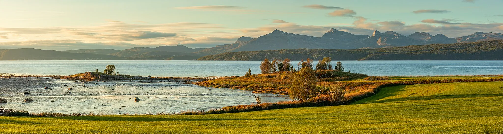 Photo showing: A view towards the small island Indre Klubben and the shores at Lundneset at Vidrek during the low tide in Narvik, Nordland, Norway in 2023 September. The wide fjord ahead is Ofotfjorden. Far ahead numerous mountains of Evenes and Tjeldsund are visible.