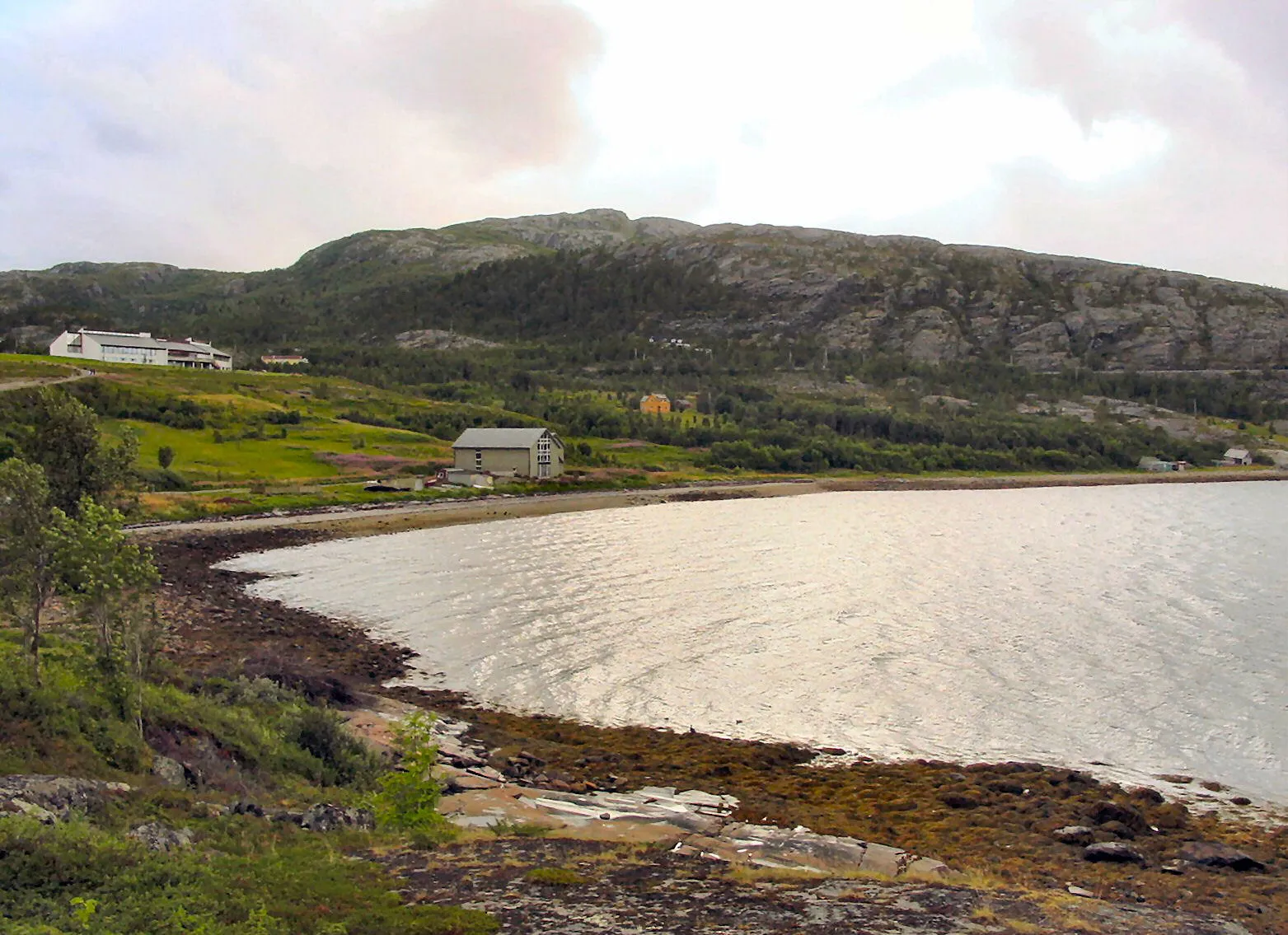 Photo showing: The Alta Rock Carving Museum, a UNESCO World Heritage Site. The museum building is the one to the left, and the carvings themselves are found on various bare rock between the building and the stony beach. 
Photo taken by Bjørn Christian Tørrissen (uspn@wikipedia) in August 2004 in Alta, Norway. The photo is part of an on-line Finnmark gallery, at http://www.pvv.org/~bct/finnmark/