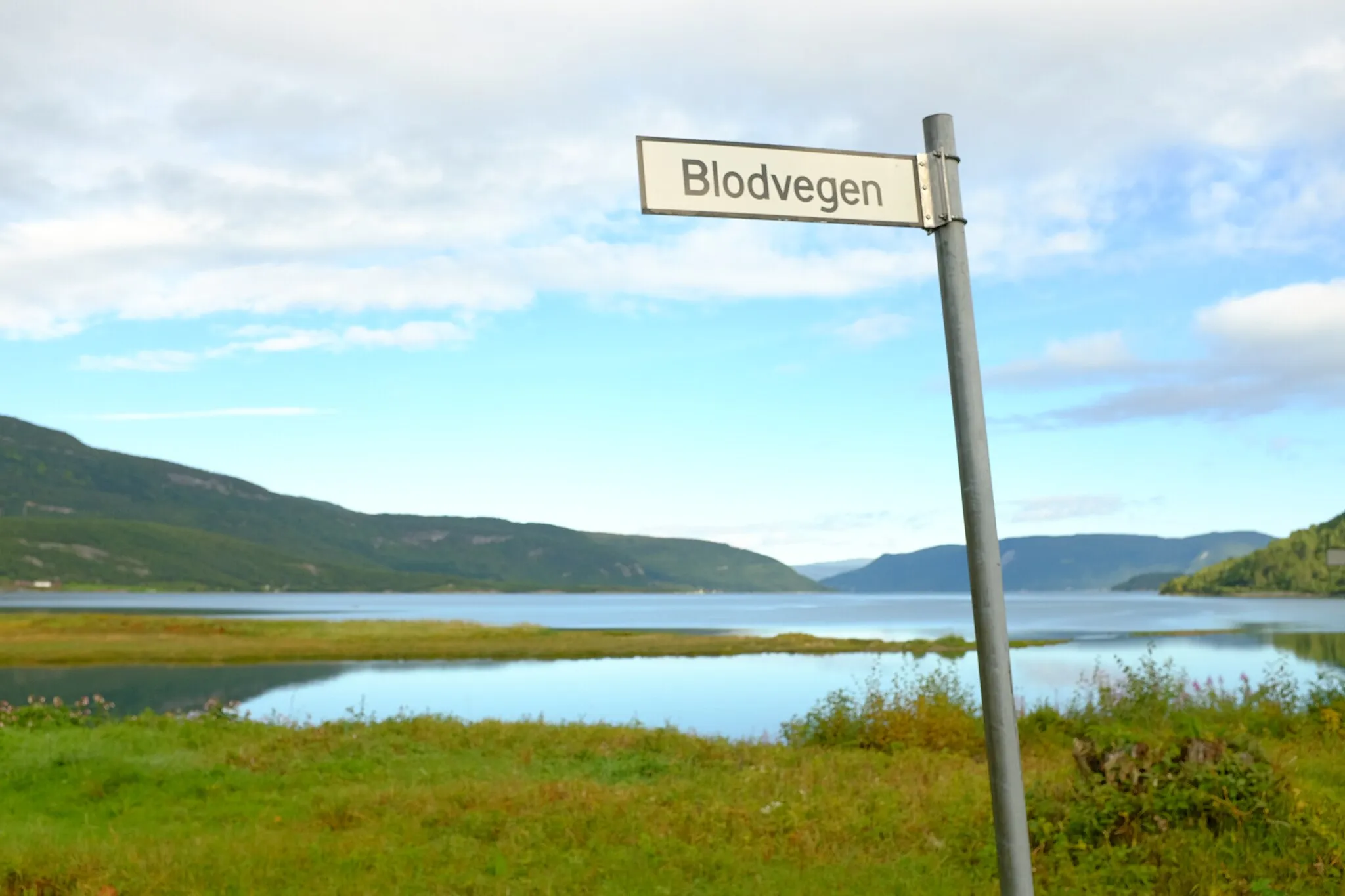 Photo showing: Blodveien is a stretch of road northeast of Rognan in Saltdal in Nordland that was built by prisoners of war during World War II. The road was a new parcel of national road 50 between Rognan and Langset on the east side of Saltdalsfjorden. The specific incident that gave the road its name was a cross of blood that was painted on a rock wall  in June 1943. The blood came from a prisoner was shot by a Wehrmacht soldier, and the cross was painted by his brother.